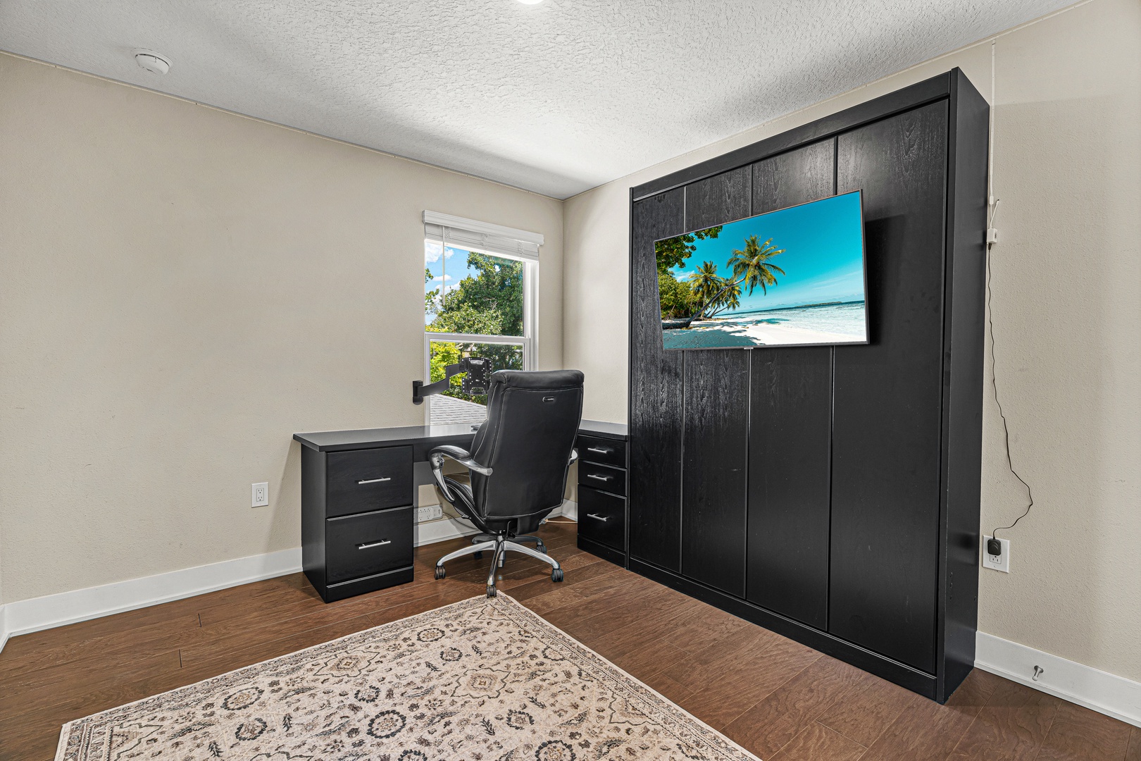Your private workspace features a sleek Murphy bed system and ergonomic desk setup, with natural light streaming through the window overlooking greenery. Perfect for working remotely in comfort.