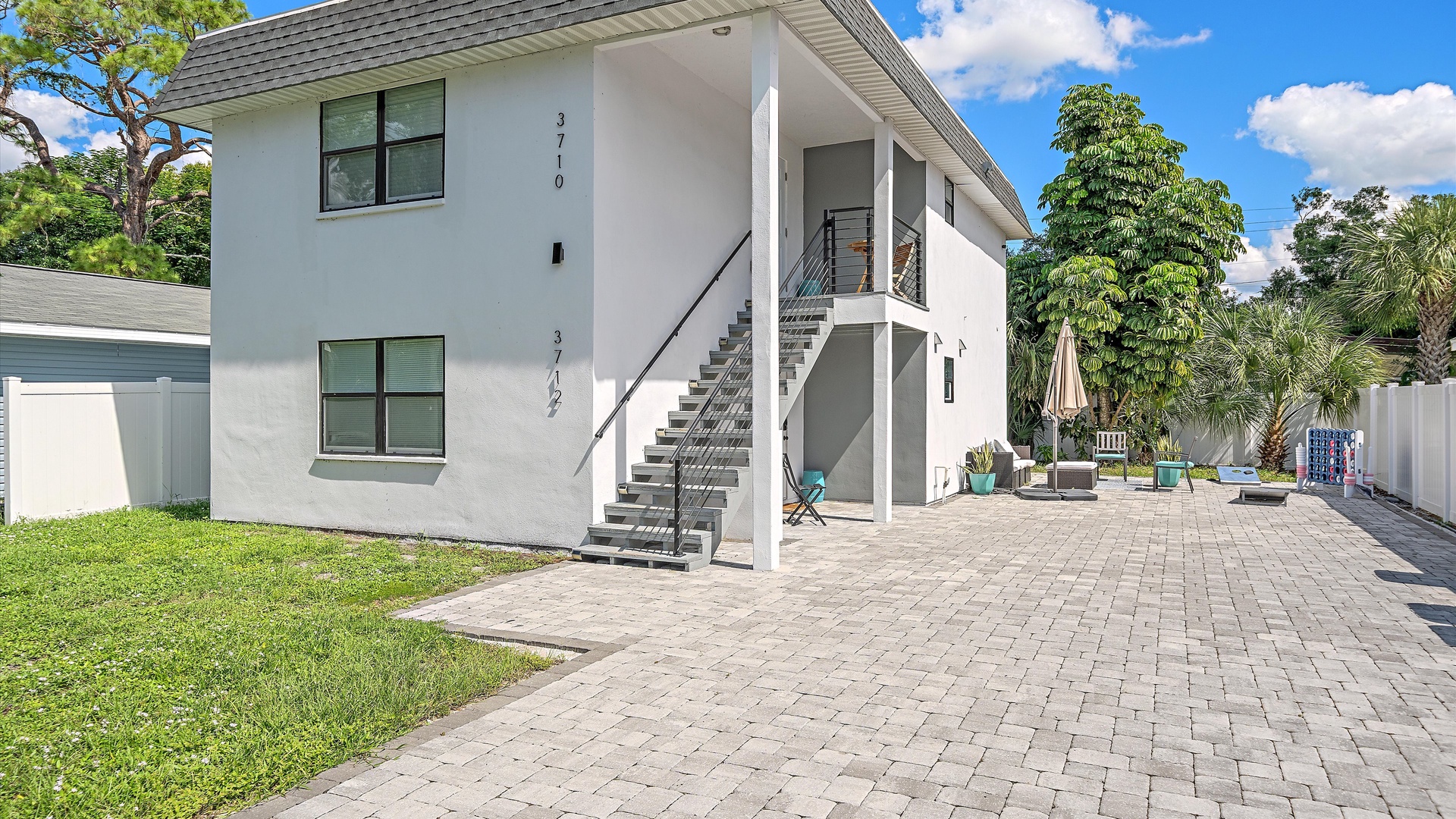 Modern two-story property with private patio and lush tropical surroundings, offering comfortable outdoor spaces for relaxation.