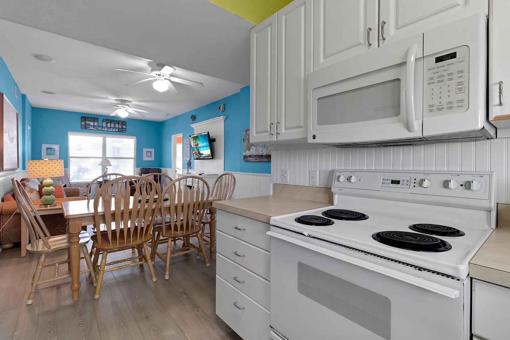Bright, open space with a full kitchen equipped with stove, microwave, and everything you need for easy meal prep. The cheerful dining area and sunny living room create a welcoming spot to gather after beach adventures.