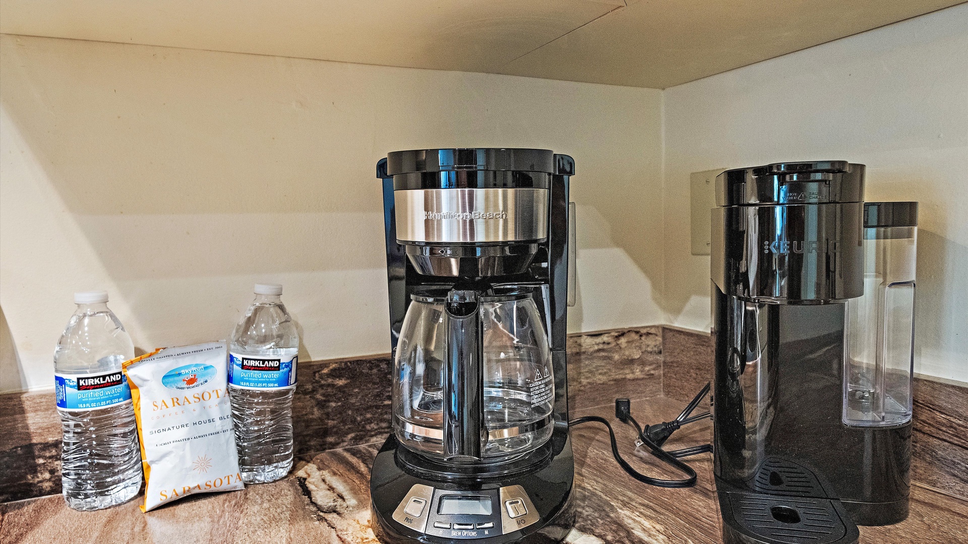 Your mornings start easy with fresh coffee brewing in your fully equipped kitchenette, complete with a sleek coffee maker and purified water ready for you.
