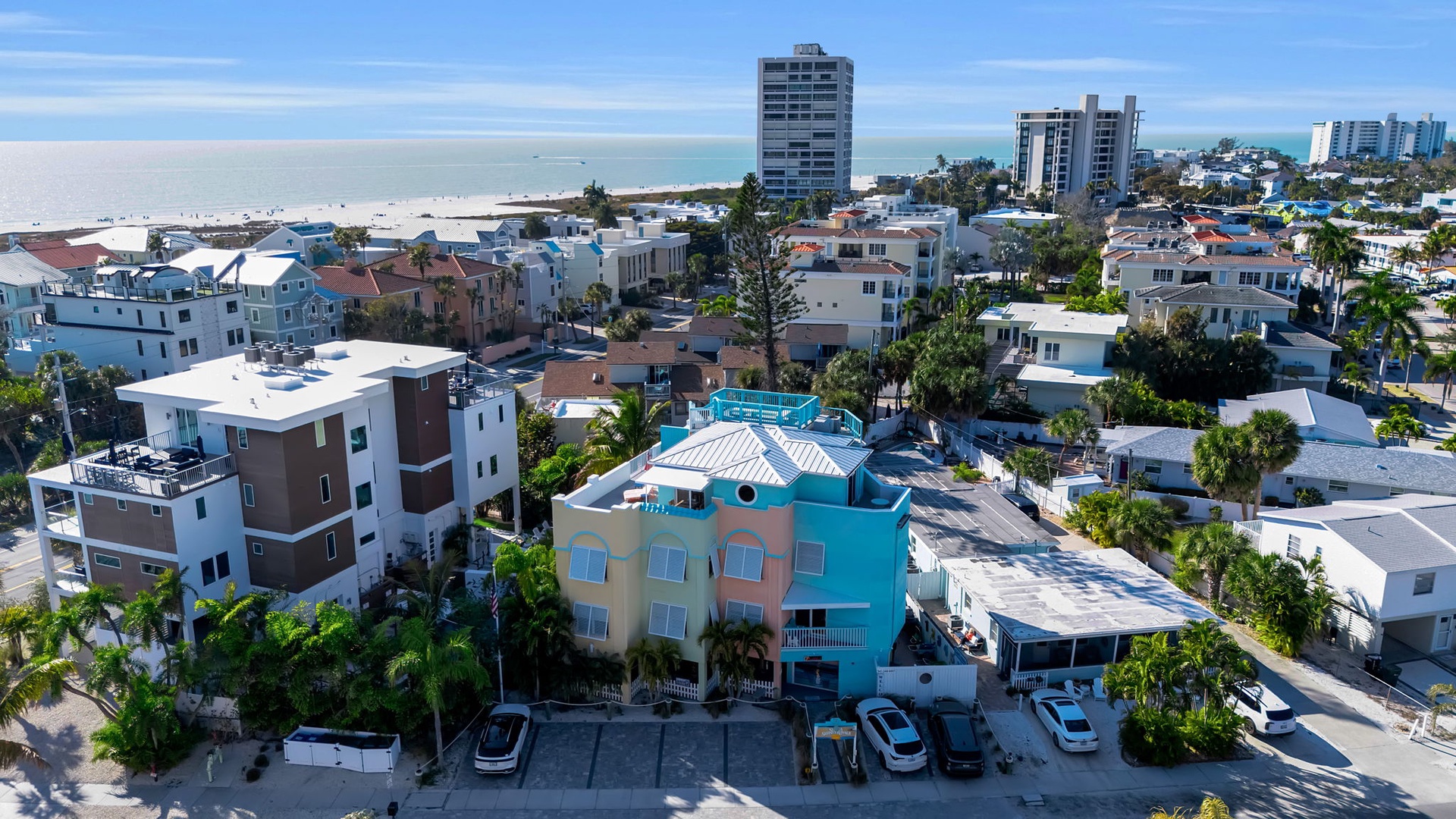 Vibrant beach community with colorful architecture nestled between ocean shores and modern coastal development.