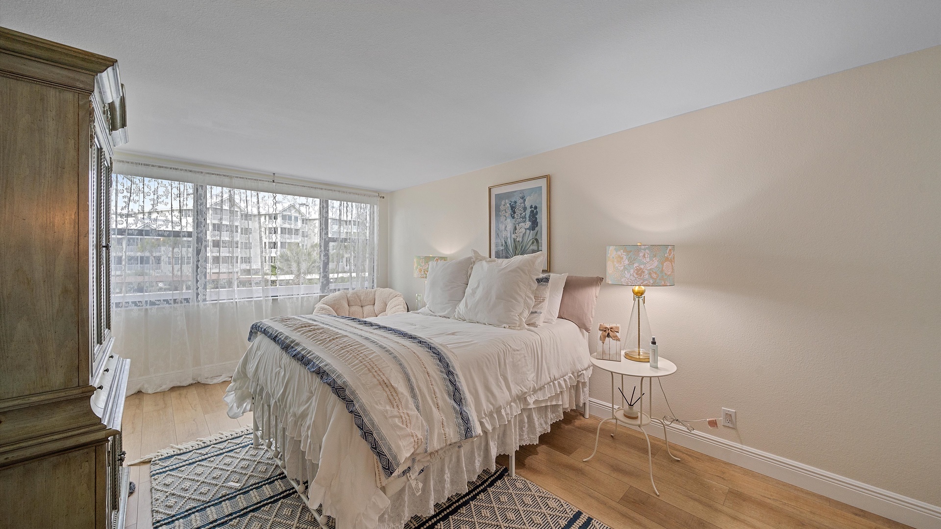 Drift off peacefully in this serene bedroom where soft linens meet natural light streaming through large windows, creating your perfect retreat.