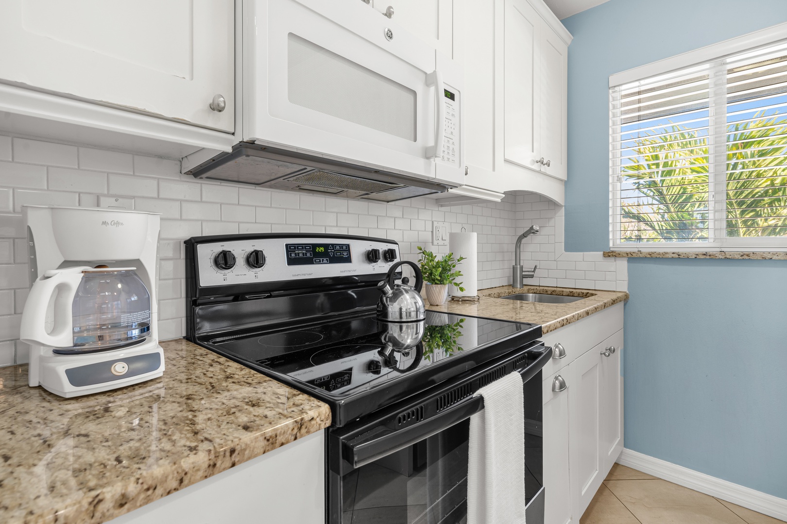 Your fully equipped kitchen features granite counters, stainless appliances, and a tropical garden view to inspire your culinary adventures.