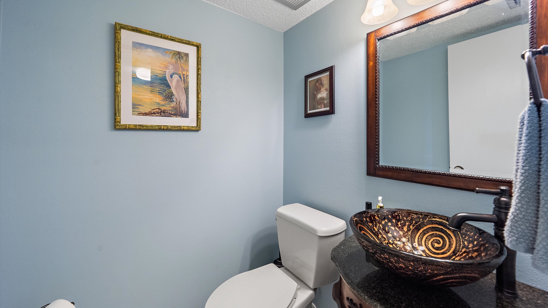 Refresh in your elegant powder room featuring a stunning vessel sink and coastal artwork that creates a serene retreat.
