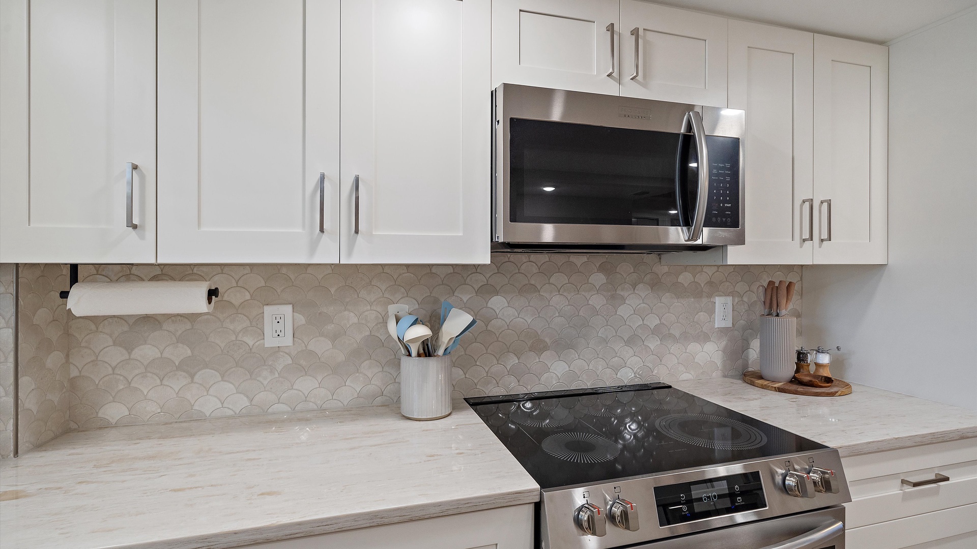 Your modern kitchen features sleek white cabinets, marble countertops, and top-tier appliances ready for your culinary adventures.