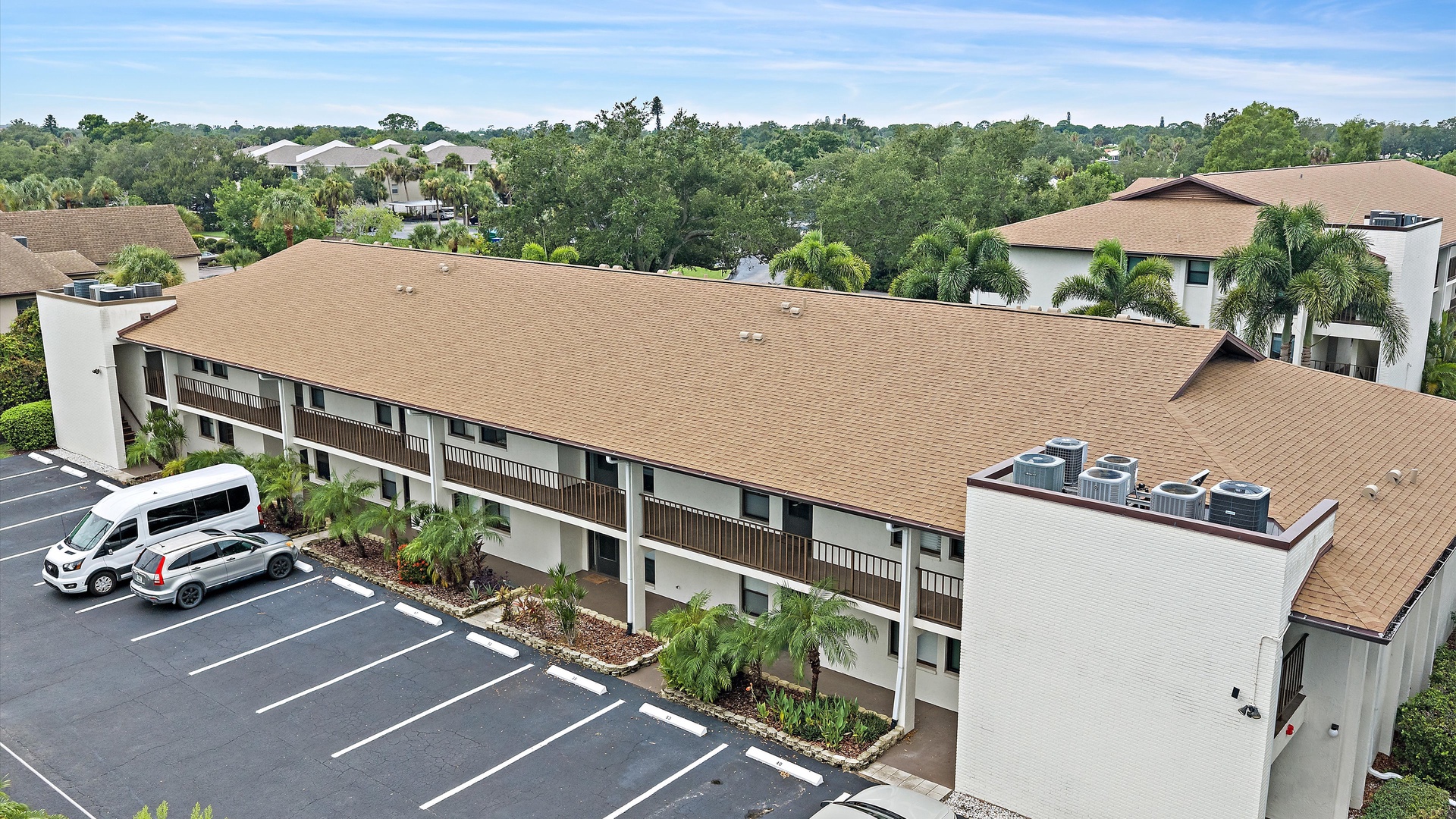 The property is nestled in a lush neighborhood with abundant greenery and palm trees, offering a peaceful setting with convenient on-site parking for guests.