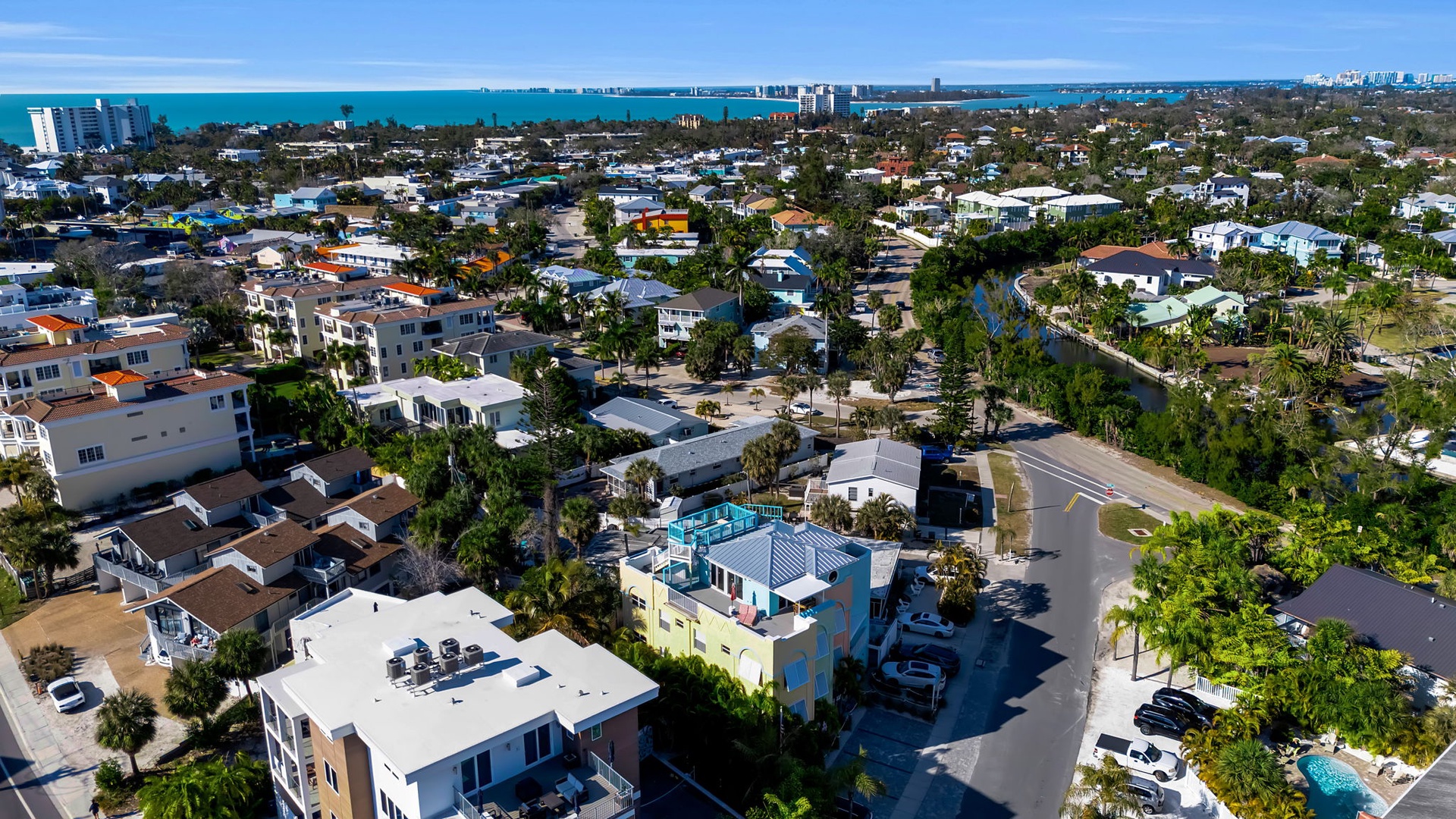 Aerial view of the coastal neighborhood surrounding the property, showcasing its ideal location near the turquoise waters and vibrant community.