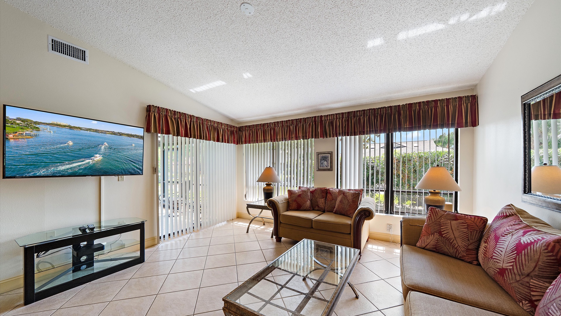 Settle in and unwind with a bright, open living space where soft sofas and warm lamps invite you to relax while enjoying your favorite shows on the large TV.