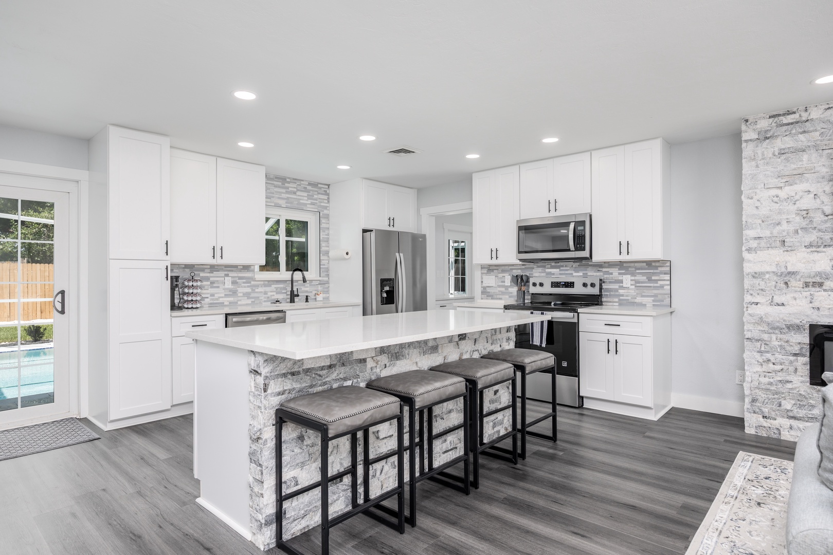 Your modern kitchen invites culinary adventures with sleek white cabinets, granite countertops, and stainless steel appliances perfectly positioned for memorable meal prep.