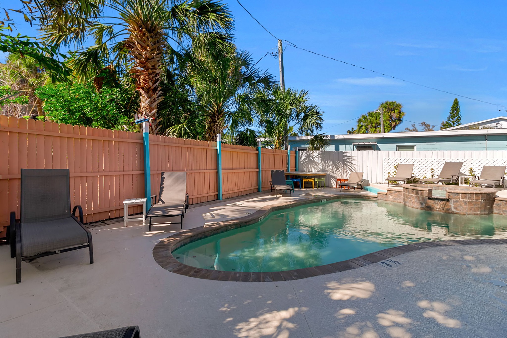 Picture yourself lounging by this sparkling pool beneath swaying palms, soaking up the Florida sunshine in your private backyard oasis.