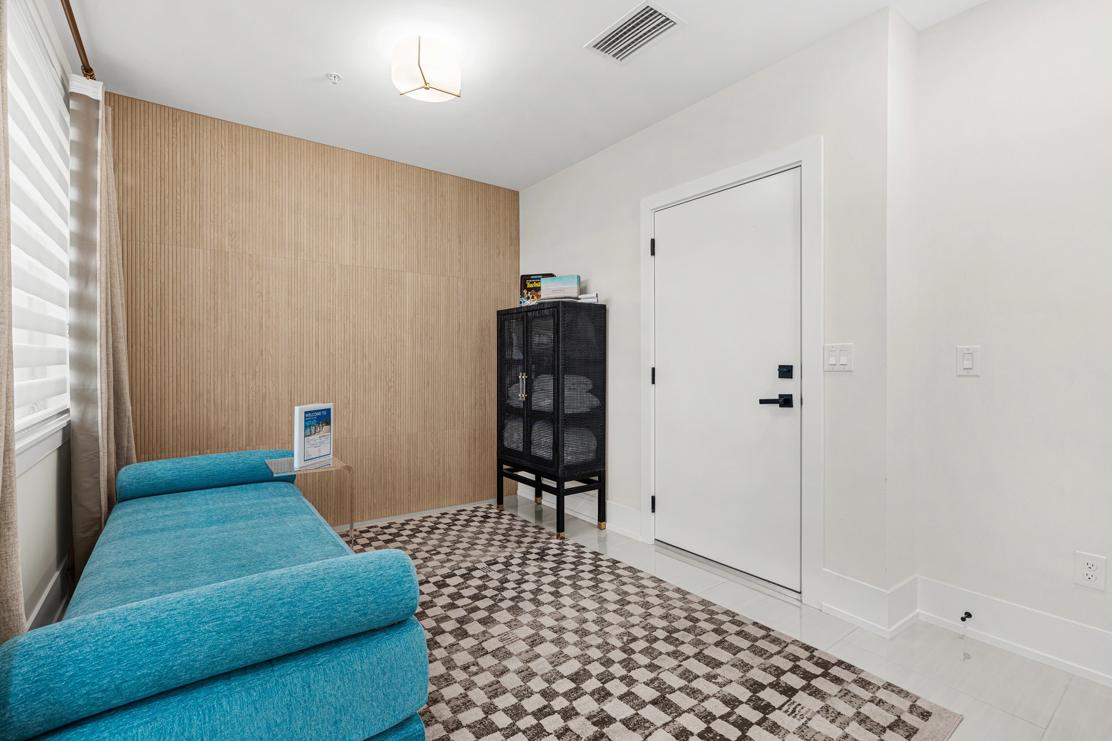 Sink into your private retreat with a cozy turquoise sofa, warm wood accents, and natural light filtering through layered shades—your quiet corner to unwind after exploring the area.