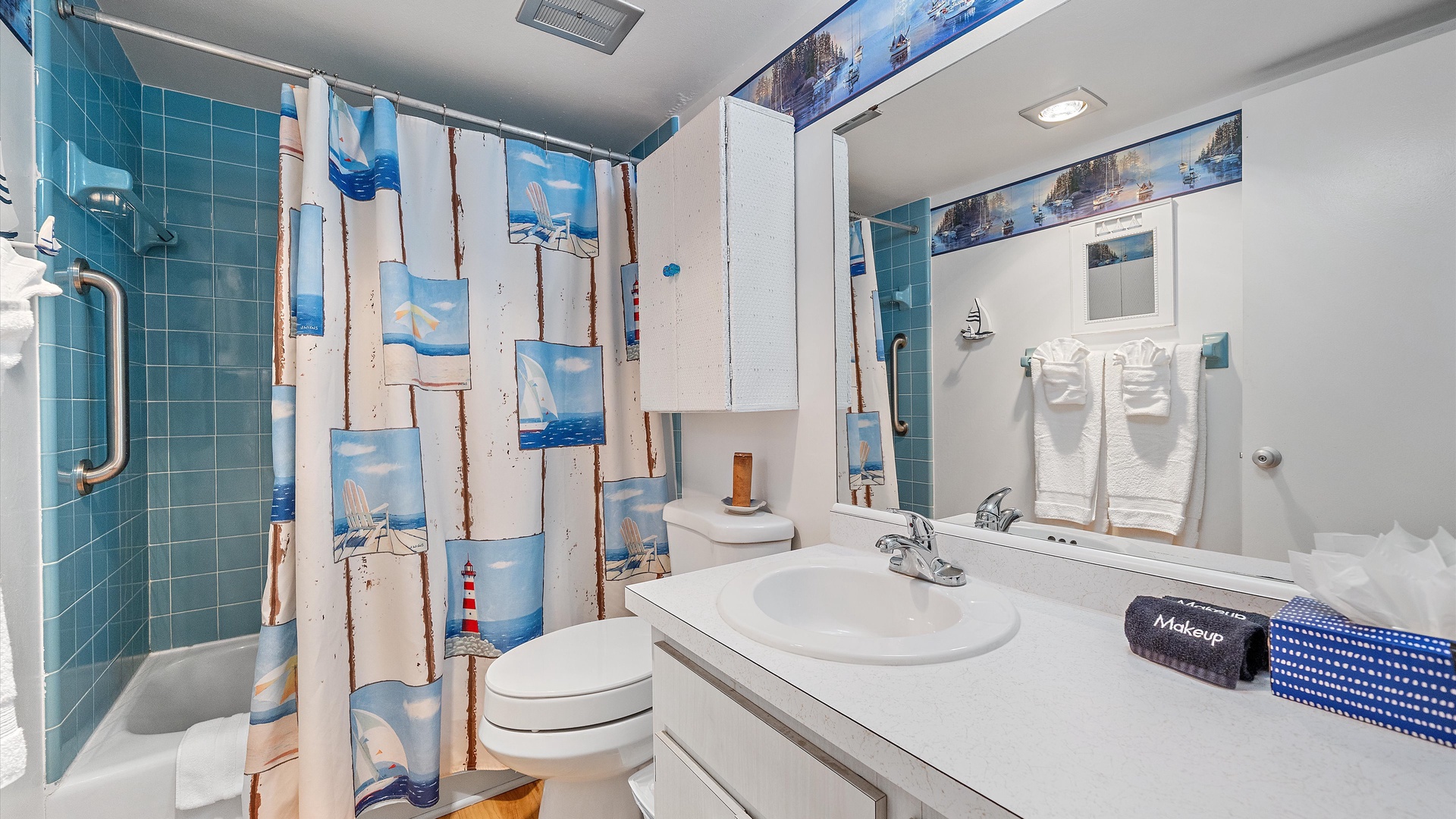 Freshen up in your nautical-themed bathroom with teal tile shower, crisp white vanity, and plush towels ready for your seaside escape.