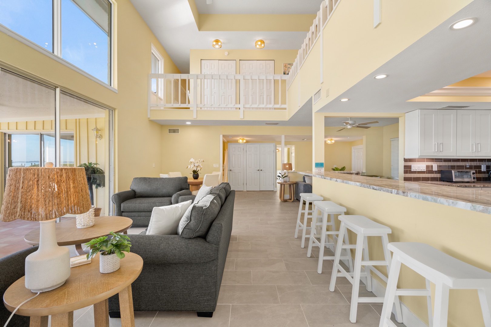 Unwind in your spacious open-concept retreat, where sunlight floods through soaring windows into a thoughtfully designed living area with coastal charm.