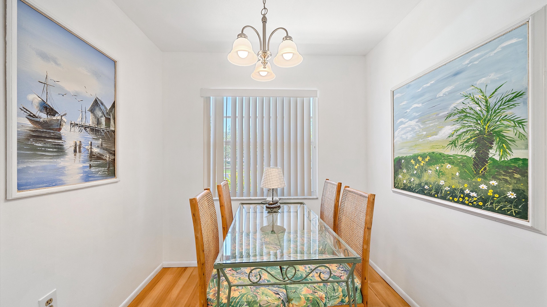 Gather around your private dining table for meals and conversation, with coastal artwork setting a relaxed, beachy mood and warm hardwood floors beneath your feet.