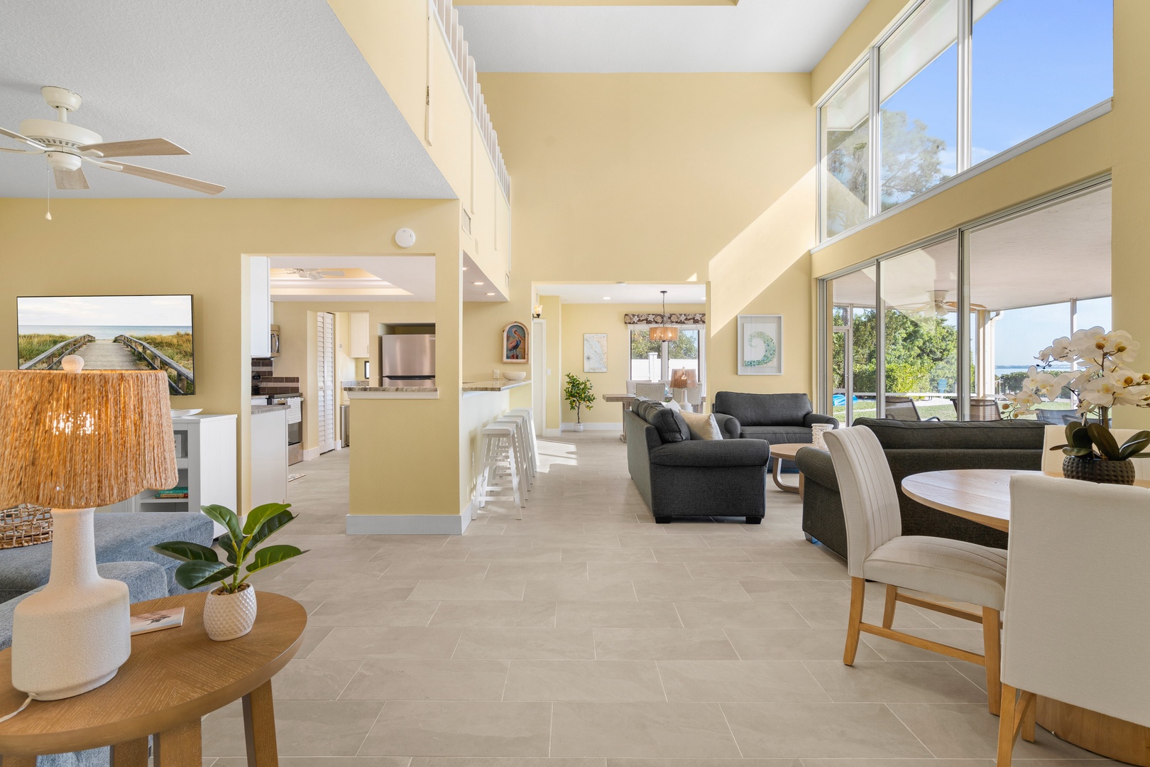 Relax in your spacious open-plan living area with soaring ceilings, modern furniture, and floor-to-ceiling windows flooding the space with natural light.