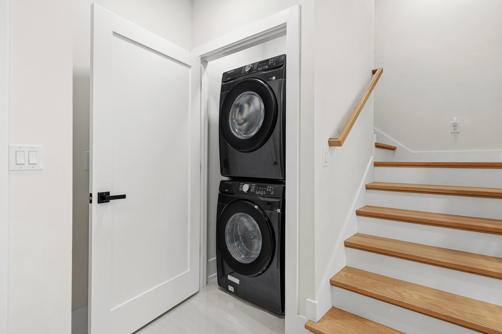 Your dedicated laundry closet features a sleek stacked washer and dryer, tucked neatly beneath the stairs—making it easy to keep your vacation wardrobe fresh without leaving the comfort of your rental.