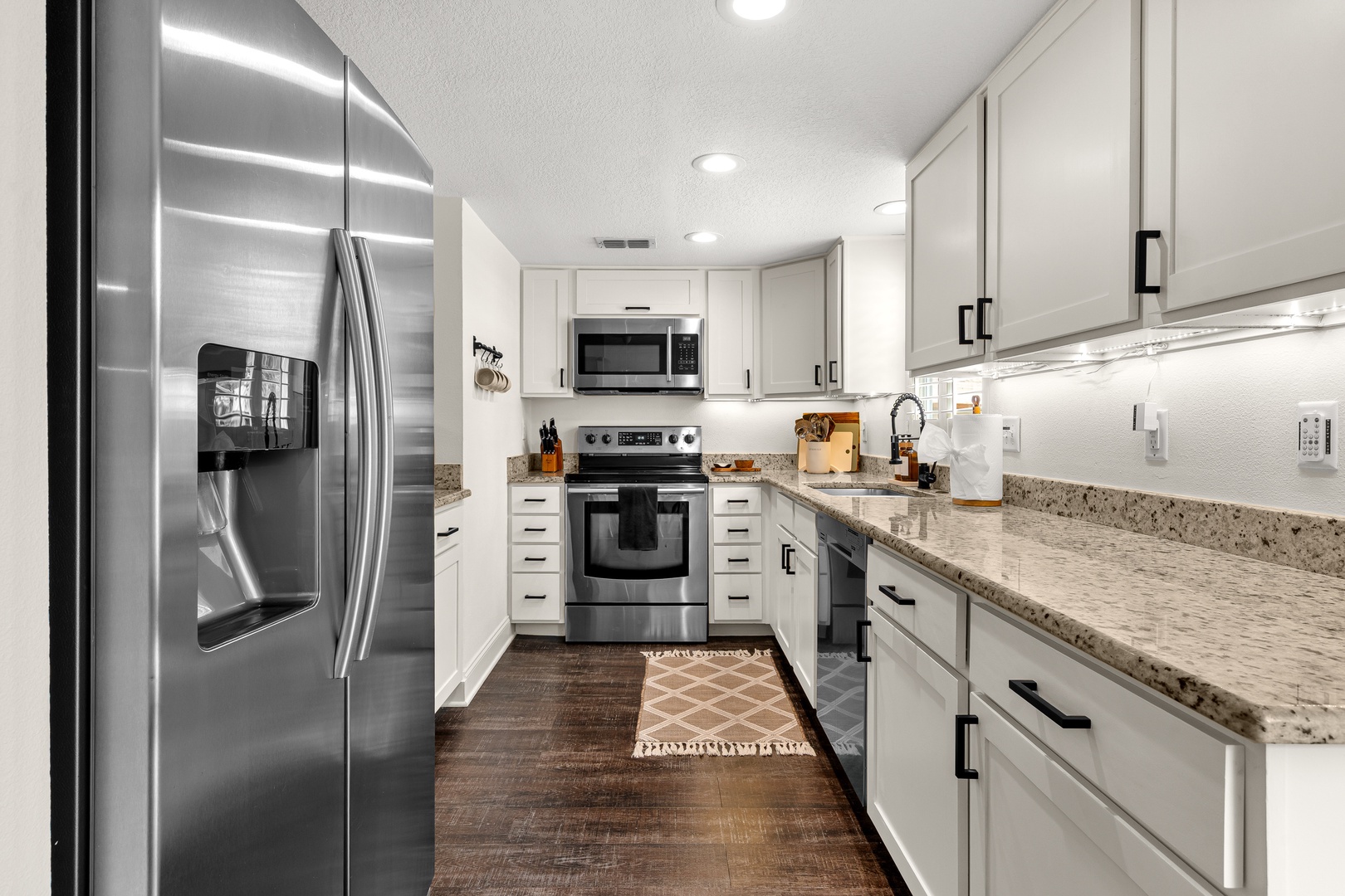 A fully-equipped kitchen with stainless steel appliances and gleaming granite countertops awaits, perfect for whipping up vacation meals or morning coffee in style.