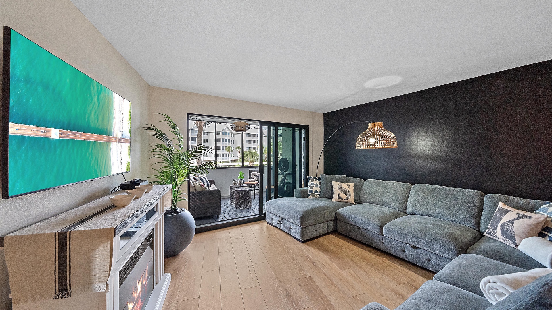 Unwind in your stylish living room featuring a comfortable sectional sofa, modern fireplace, and private balcony access with natural light streaming through large windows.