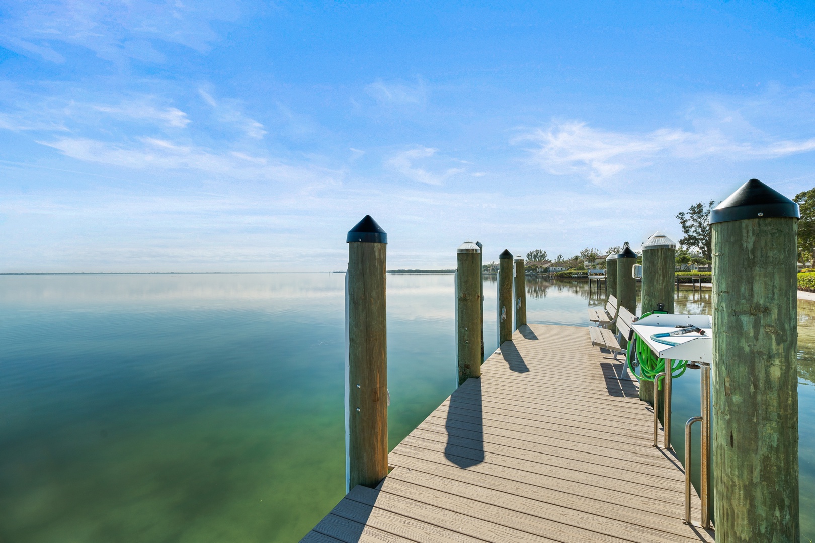 A peaceful waterfront dock extends into calm waters, offering a serene spot for fishing or watching boats pass by.