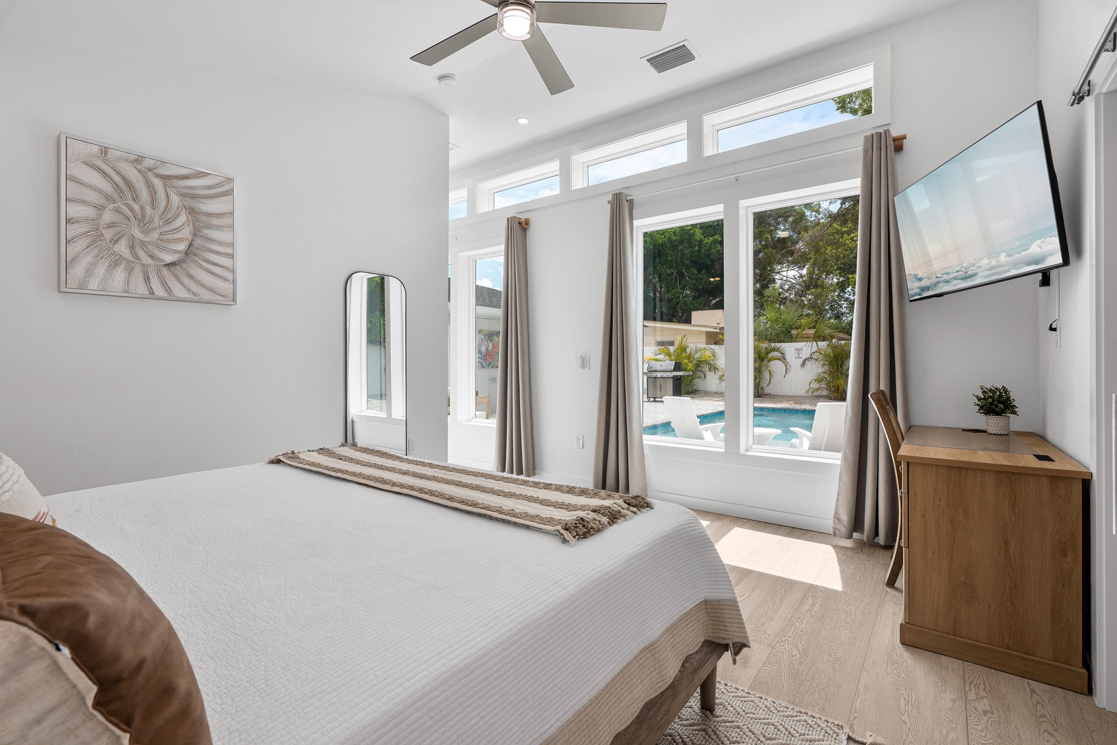 Wake up to sunlight streaming through your floor-to-ceiling windows, revealing a sparkling pool just steps away. Your serene bedroom blends comfort and elegance for a restful retreat.