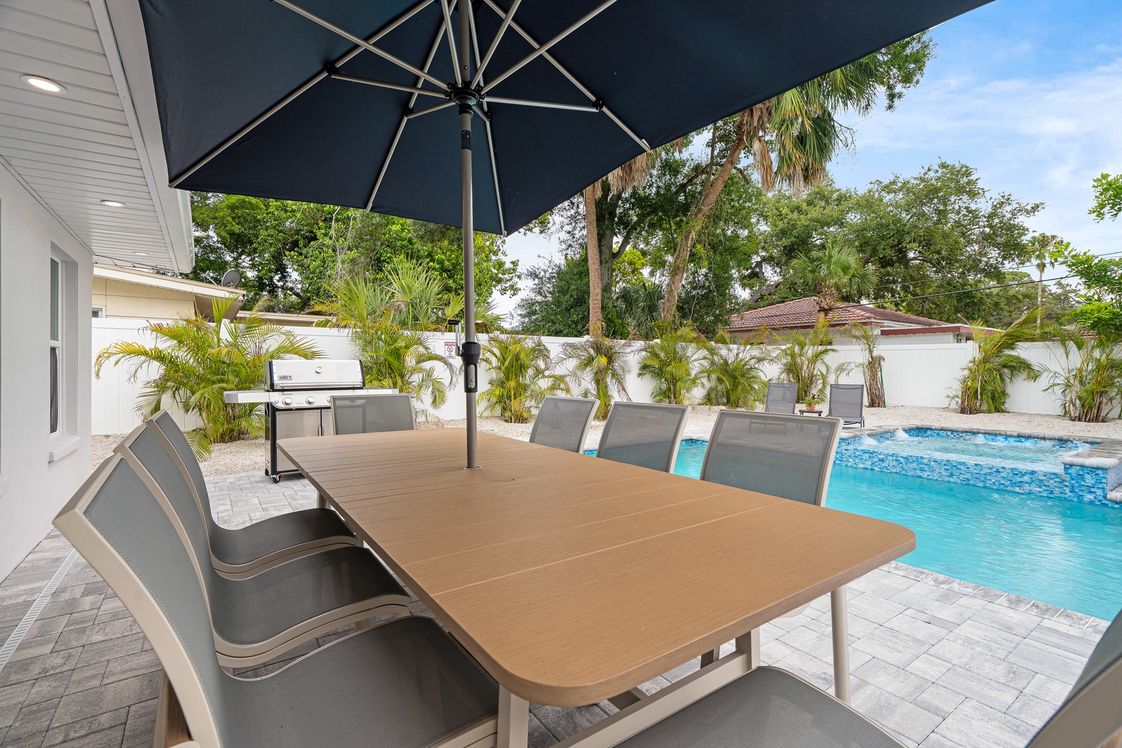 Large outdoor dining table overlooking the pool, with BBQ grill, and your perfect spot for morning coffee or sunset cocktails.