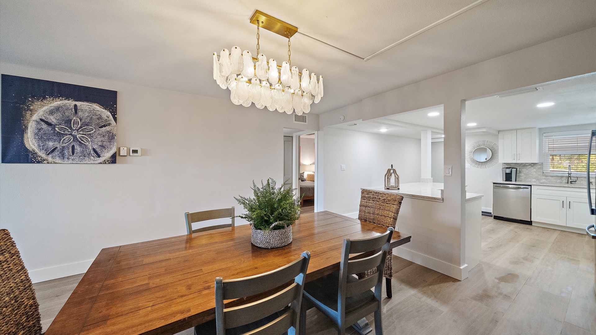 Gather around your elegant dining table beneath a stunning chandelier, while the open-concept design flows seamlessly into your fully equipped kitchen.