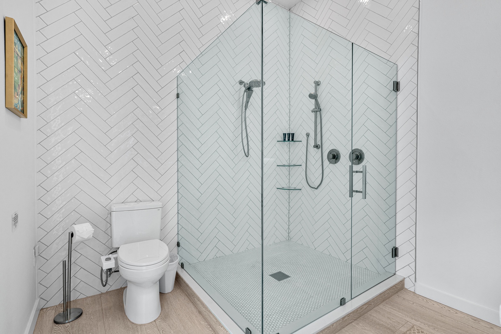 Step into your spa-like en suite, where bright white herringbone tiles and a spacious glass-enclosed walk-in shower await, creating the perfect retreat after a day of adventure.