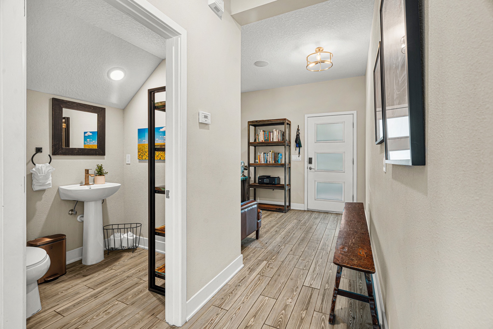Step into your private retreat with warm wood-tone floors and thoughtful touches throughout. A cozy bench invites you to settle in, while the bright bathroom awaits just steps away.