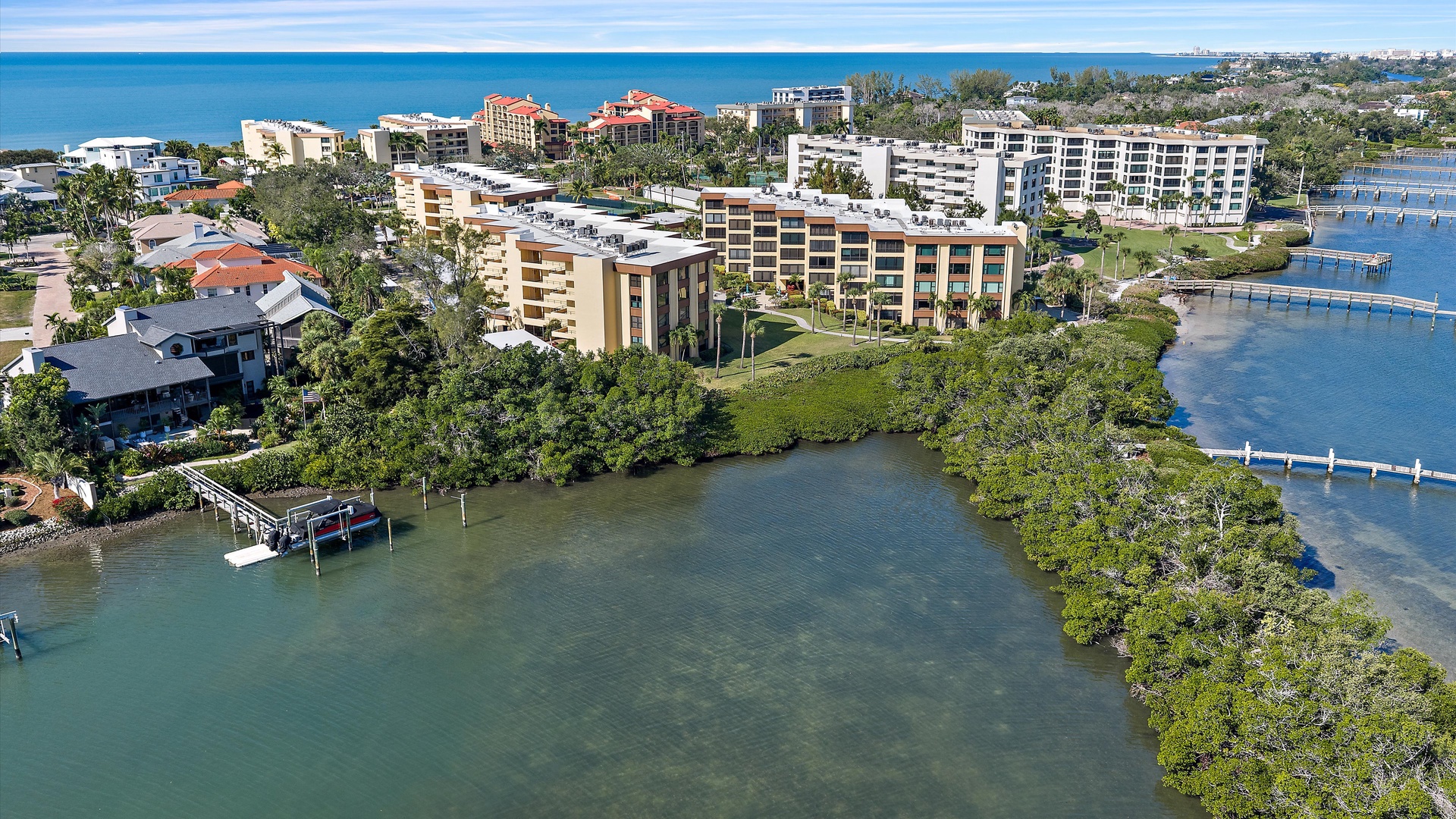 Waterfront vacation rentals nestled between pristine bay waters and tropical coastline, offering prime location near marinas and beaches.