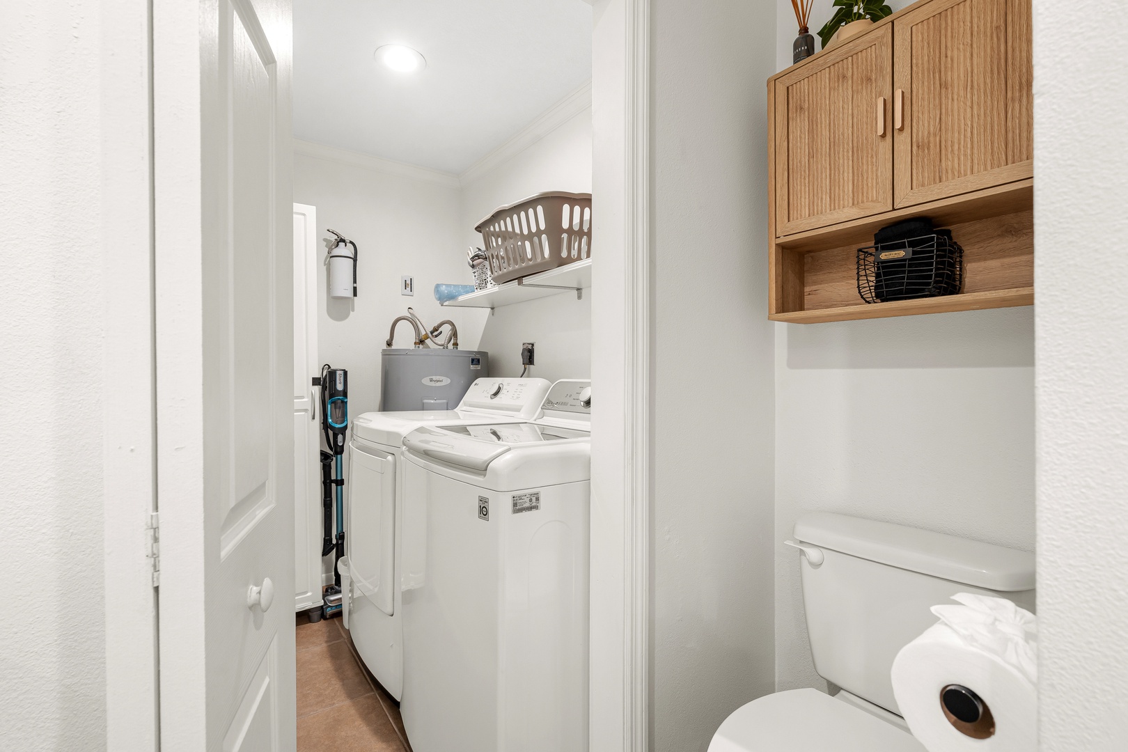 A dedicated laundry area featuring a full-size washer and dryer, plus convenient storage and neatly organized shelving to keep your essentials within easy reach.