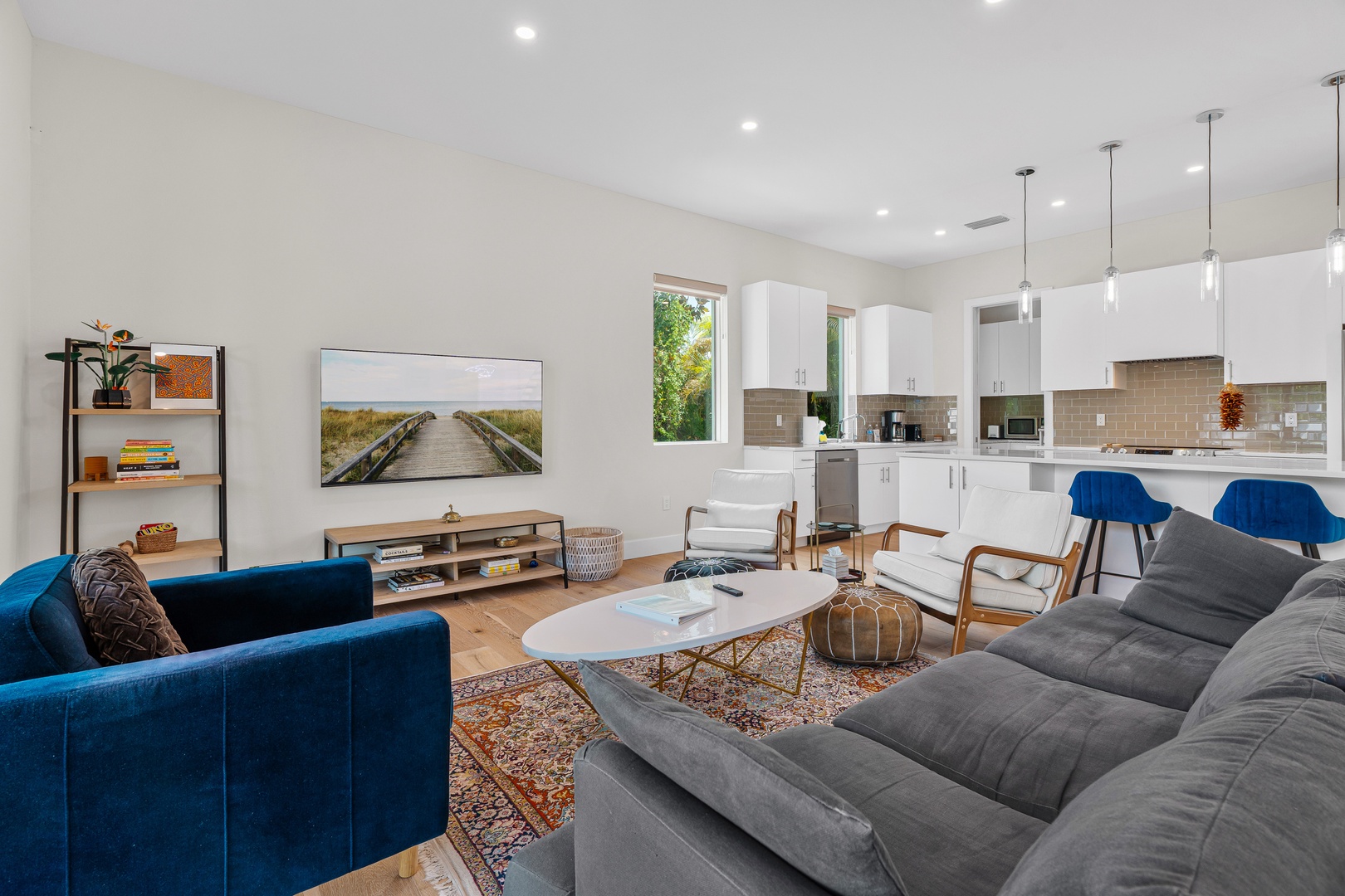 Picture yourself unwinding on plush sofas in this bright, open living space. The modern kitchen beckons for morning coffee, while natural light and high ceilings create an airy, welcoming retreat for your entire group.