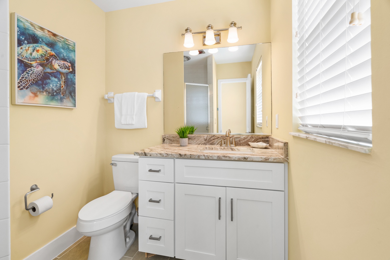 Refresh in your bright, coastal-themed bathroom with marble countertops and thoughtful touches that make your stay feel like home.