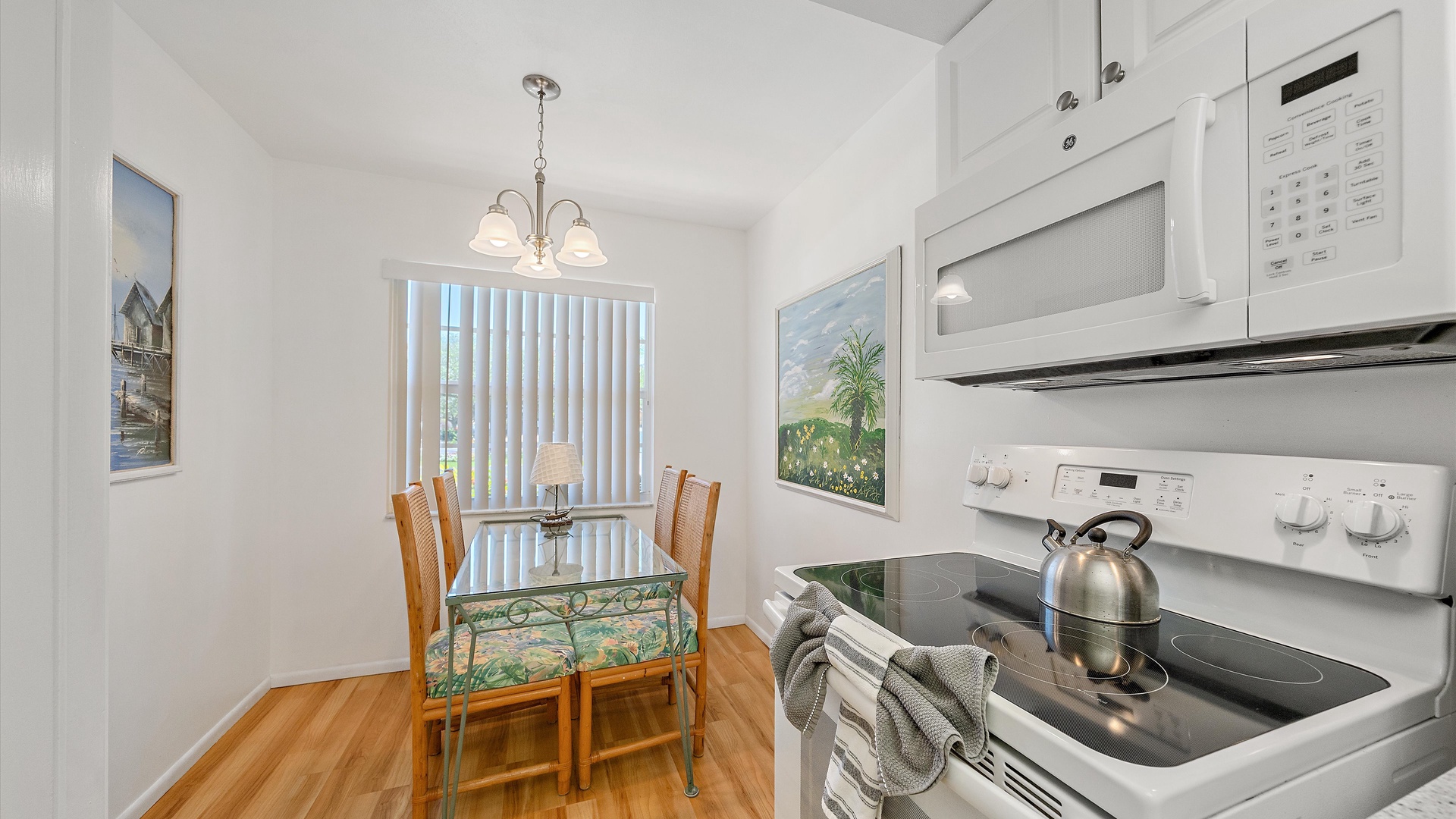 Step into your bright, cheerful kitchen and dining nook where morning coffee and sunset dinners feel equally inviting with warm wood floors and natural light streaming in.
