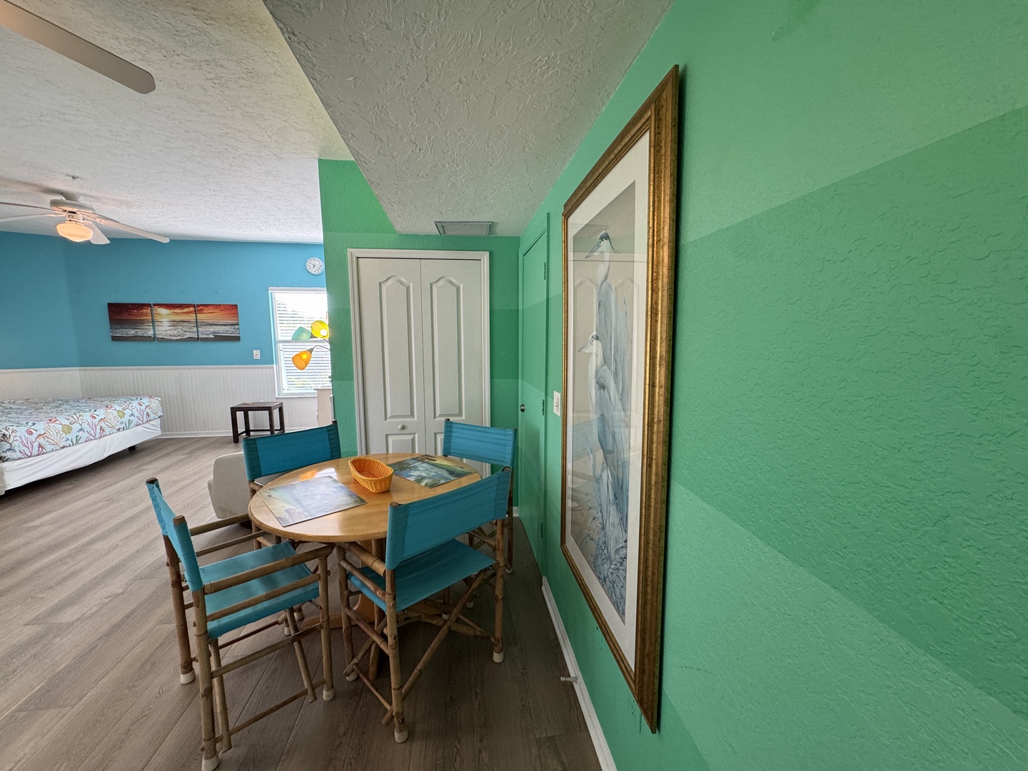 You'll love the cheerful coastal vibe here, with bright turquoise and mint green walls that bring the beach indoors. Gather around the cozy dining table or unwind in the open bedroom space—your perfect home base for seaside adventures.