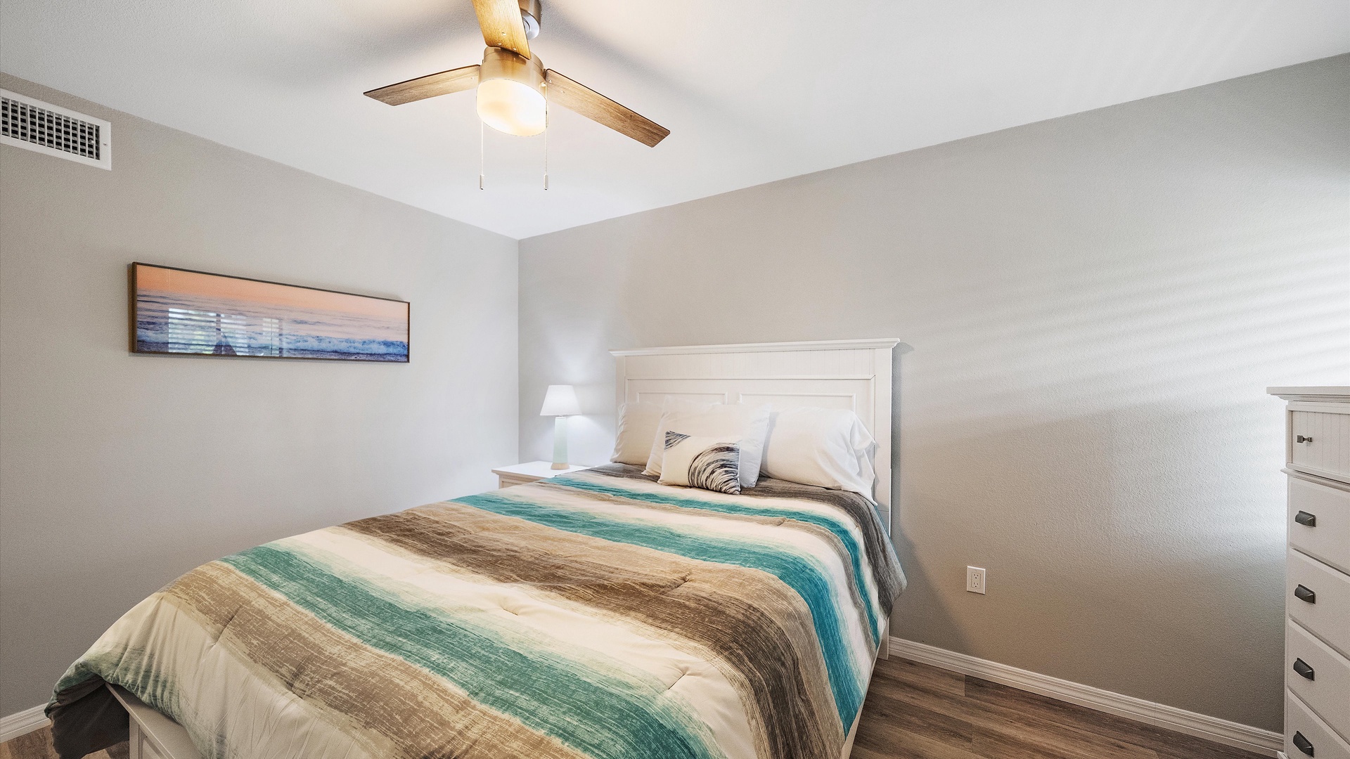 Sink into crisp linens and coastal-inspired colors that invite restful nights. Your ceiling fan keeps the air perfectly cool, while bedside lamps offer warm reading light.