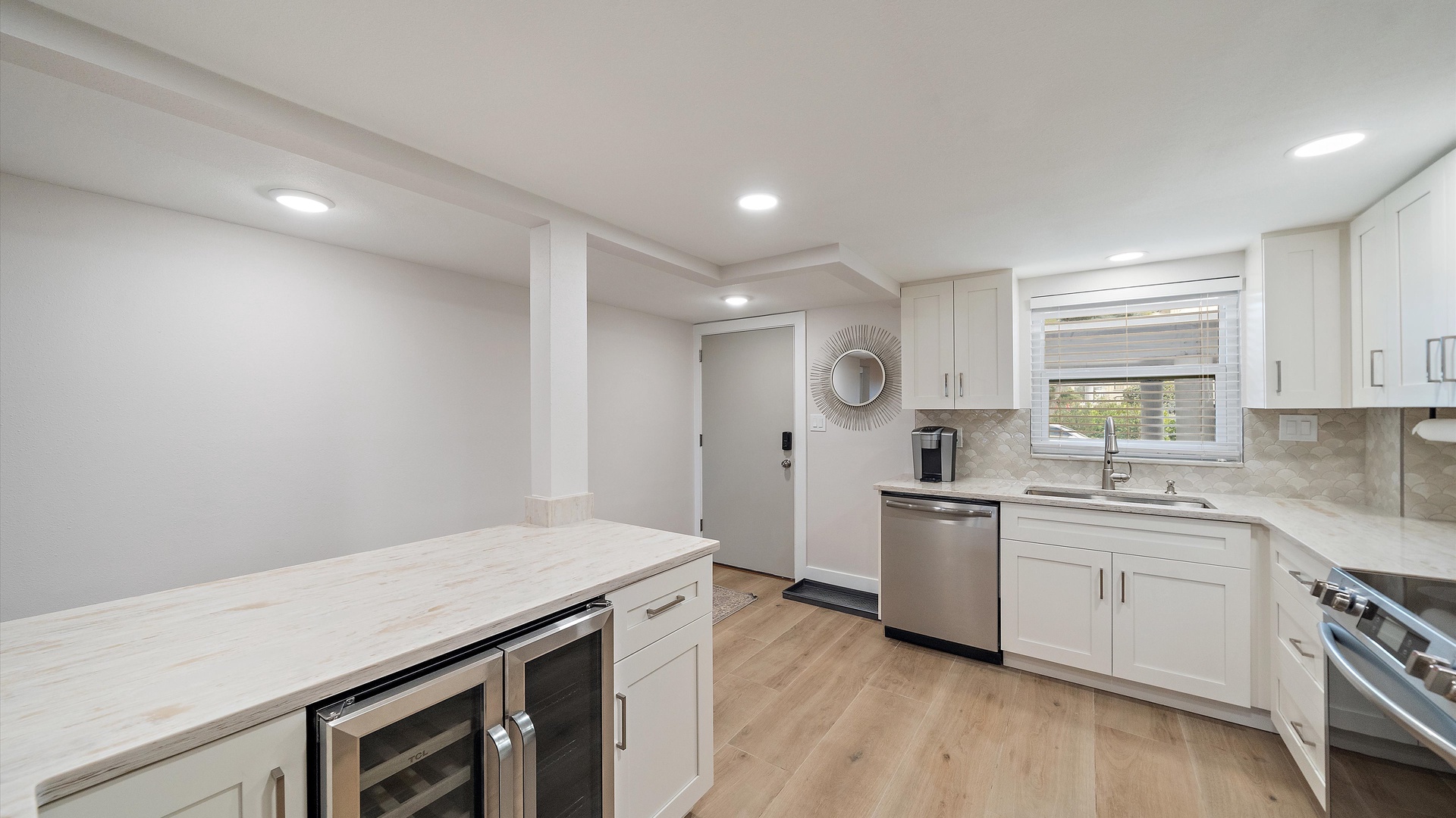 Your spacious modern kitchen awaits with pristine white cabinets, marble countertops, and professional appliances and wine cooler perfect for culinary adventures.