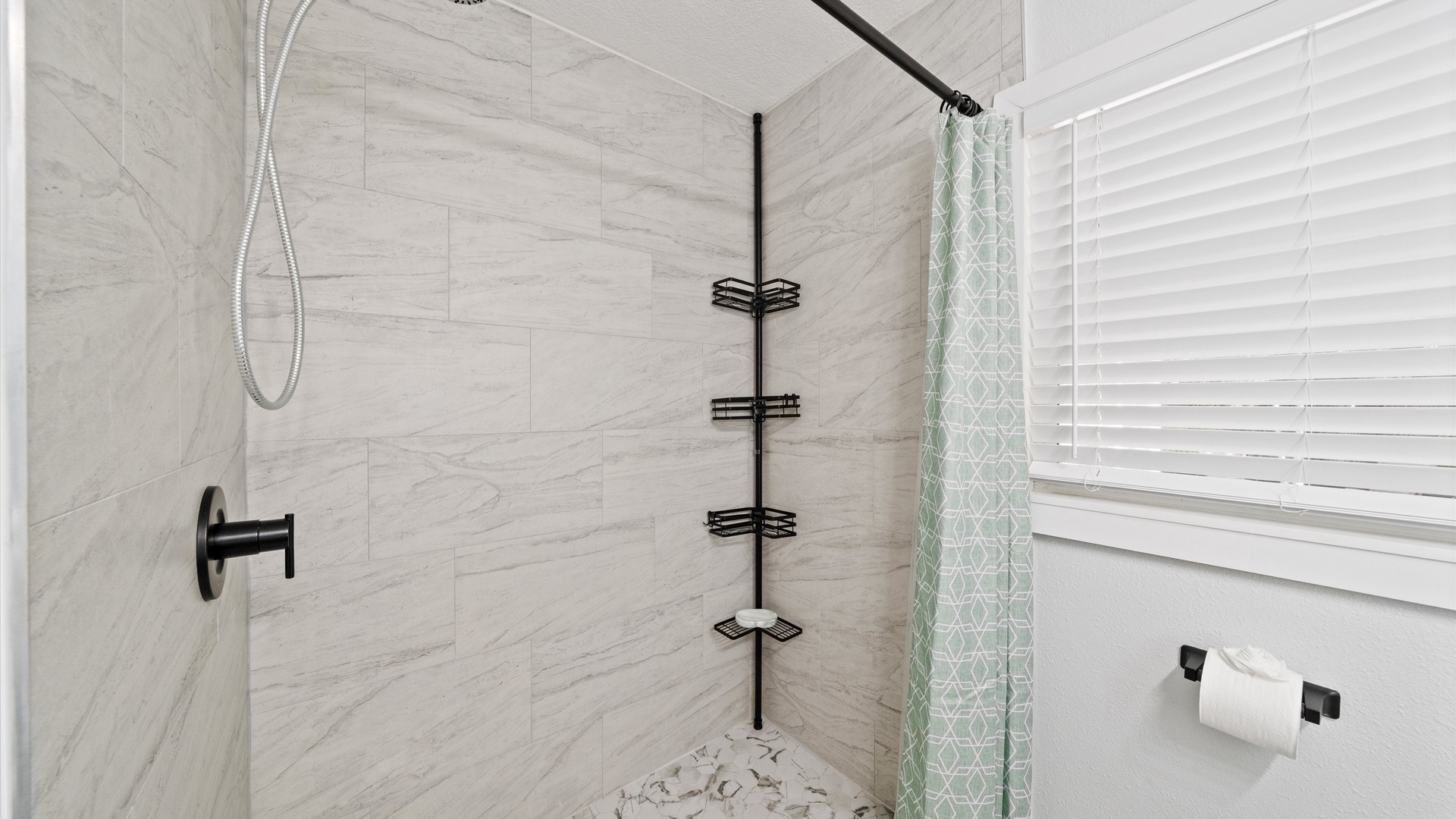 Slip into a spa-like shower with modern fixtures and elegant tiling. The sleek design and handheld showerhead make your daily routine feel indulgent.