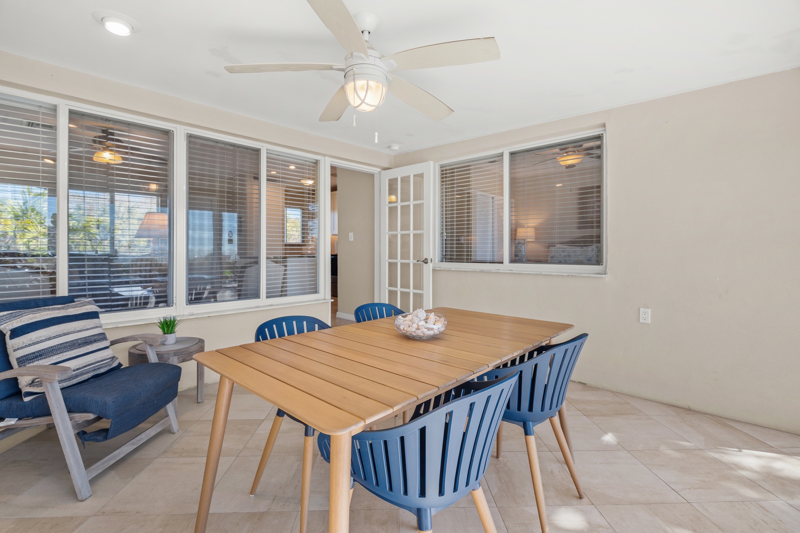 Your dining area features coastal-inspired blue chairs and warm wood table, perfect for morning coffee or evening meals together.