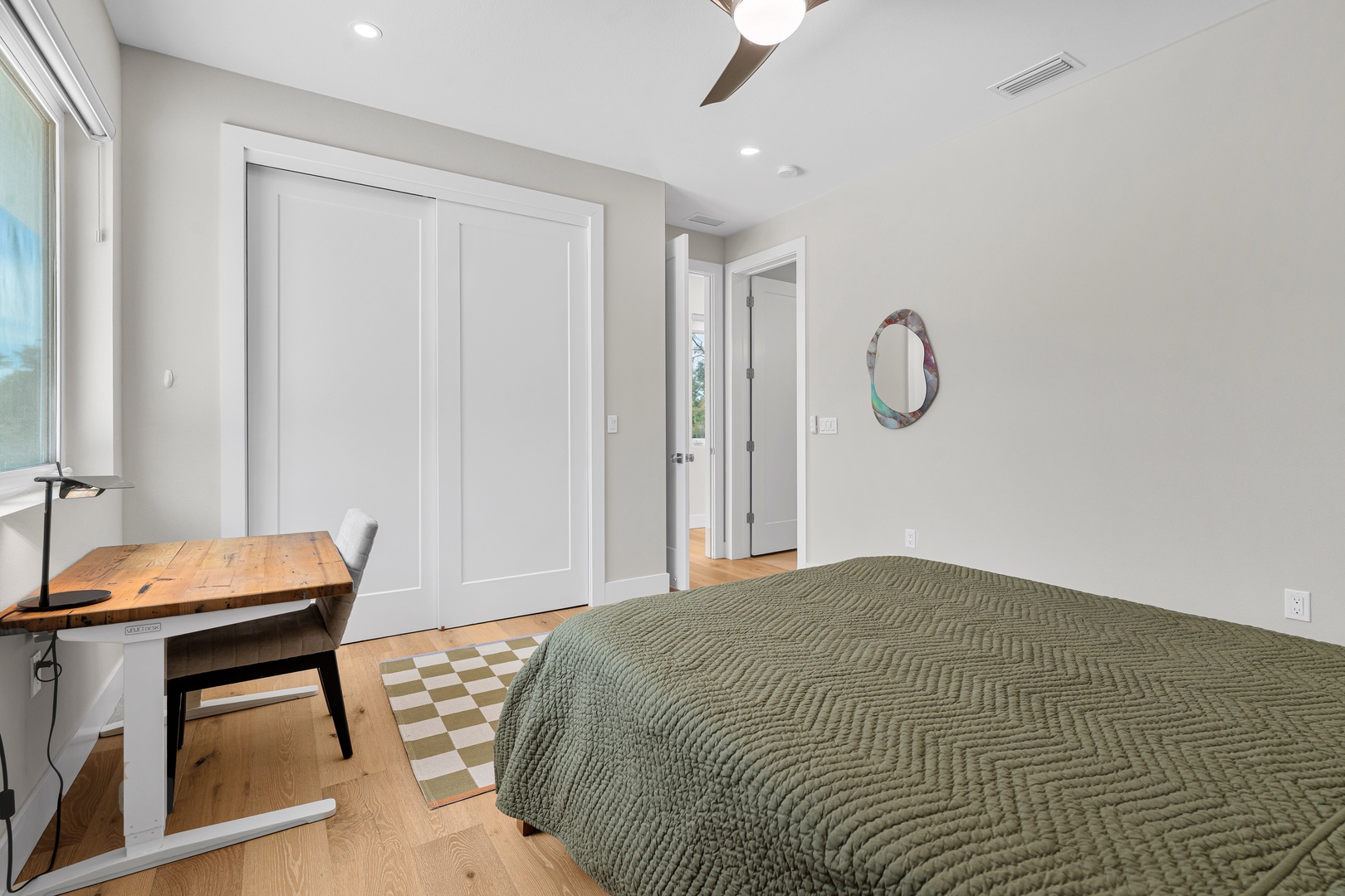 Your bright, modern bedroom features a comfortable workspace and fresh coastal vibes. Sliding wardrobe doors and a ceiling fan keep things practical, while soft natural light invites you to unwind or get a little work done.