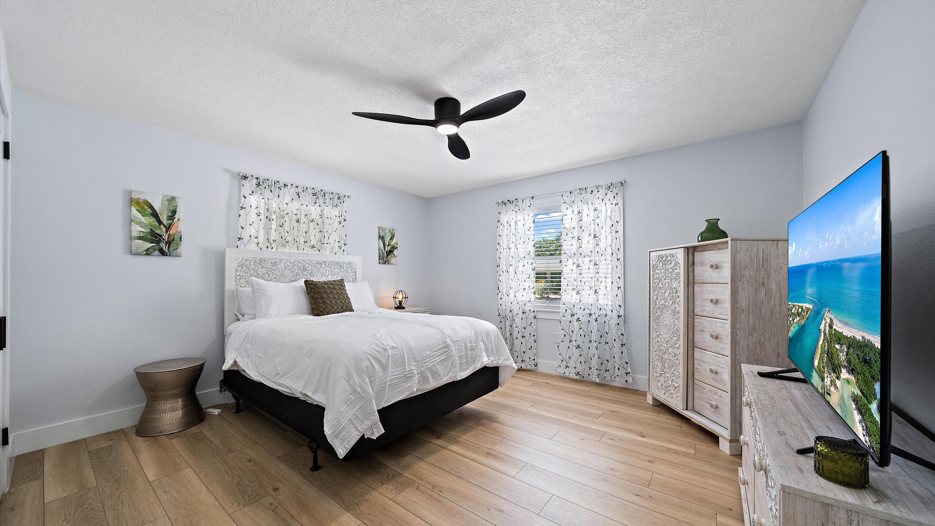 Your peaceful bedroom retreat features a plush bed with crisp linens, soft natural light streaming through airy curtains, and calming coastal decor that invites restful sleep.