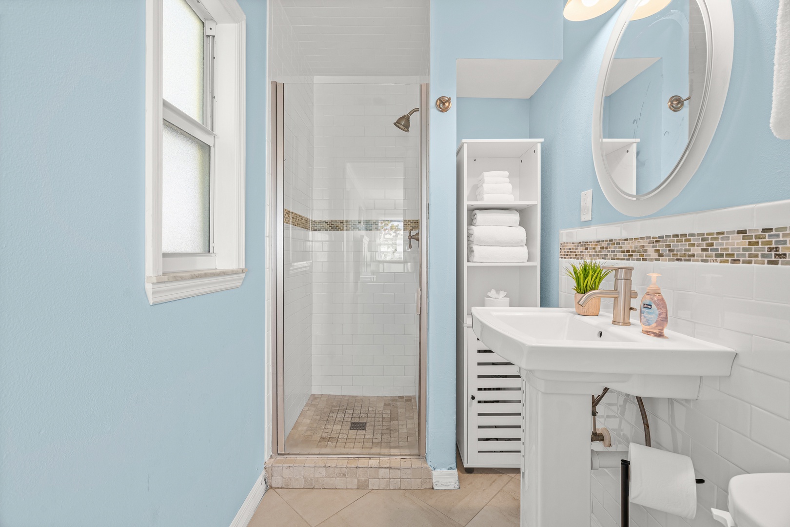 Refresh in your private spa-like bathroom with soothing blue walls and natural light streaming through.