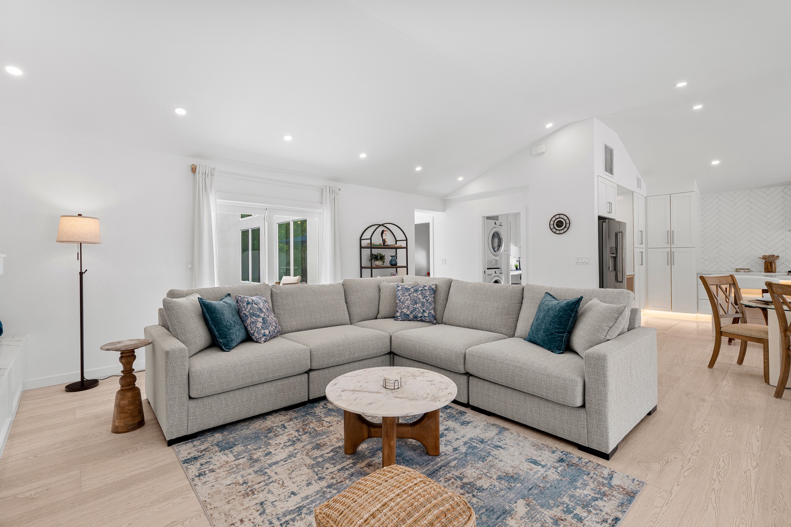 Sink into this spacious sectional in your airy open-concept living area. Soft natural light, coastal accents, and seamless flow to the kitchen make this the perfect spot to unwind after a day of exploring.