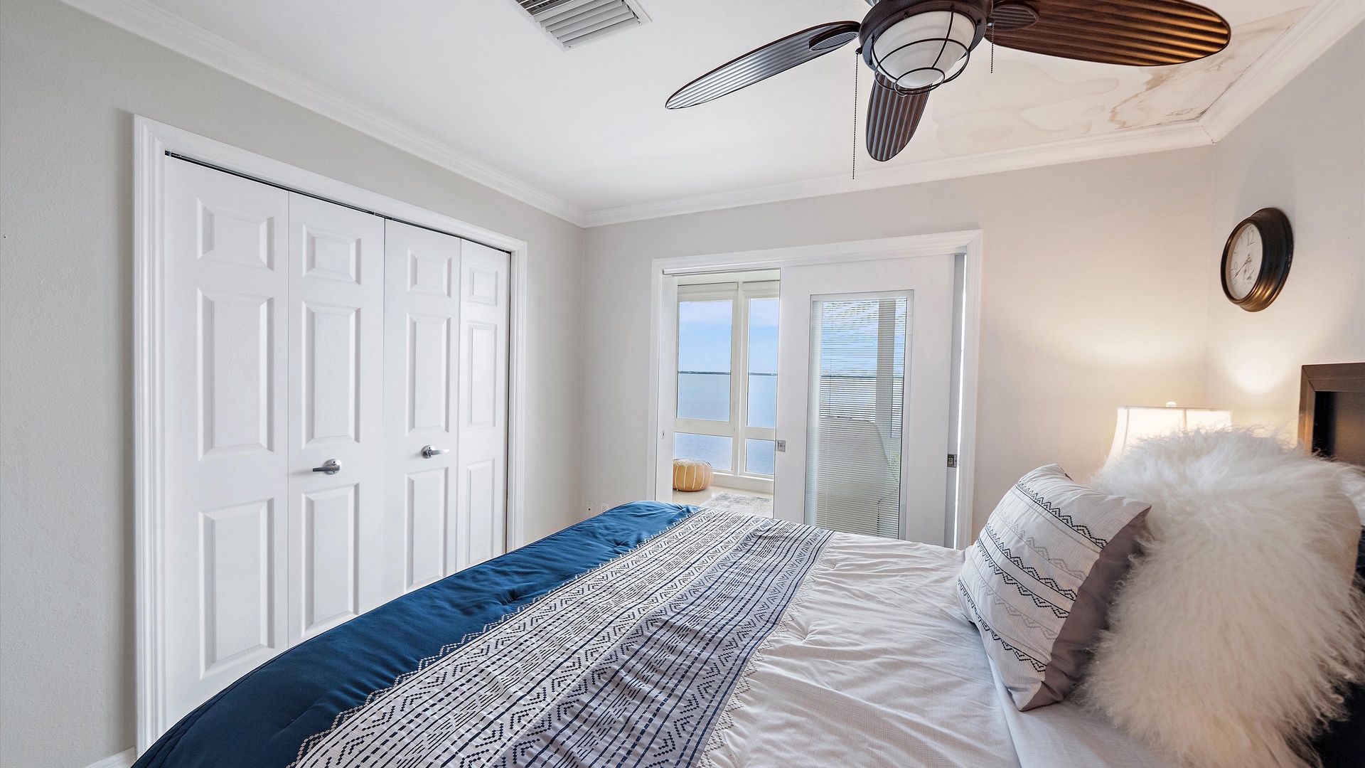 The queen bedroom opens to the enclosed sunroom, with Sarasota Bay visible beyond. This connection to the waterfront is a lovely feature shared by both bedrooms.