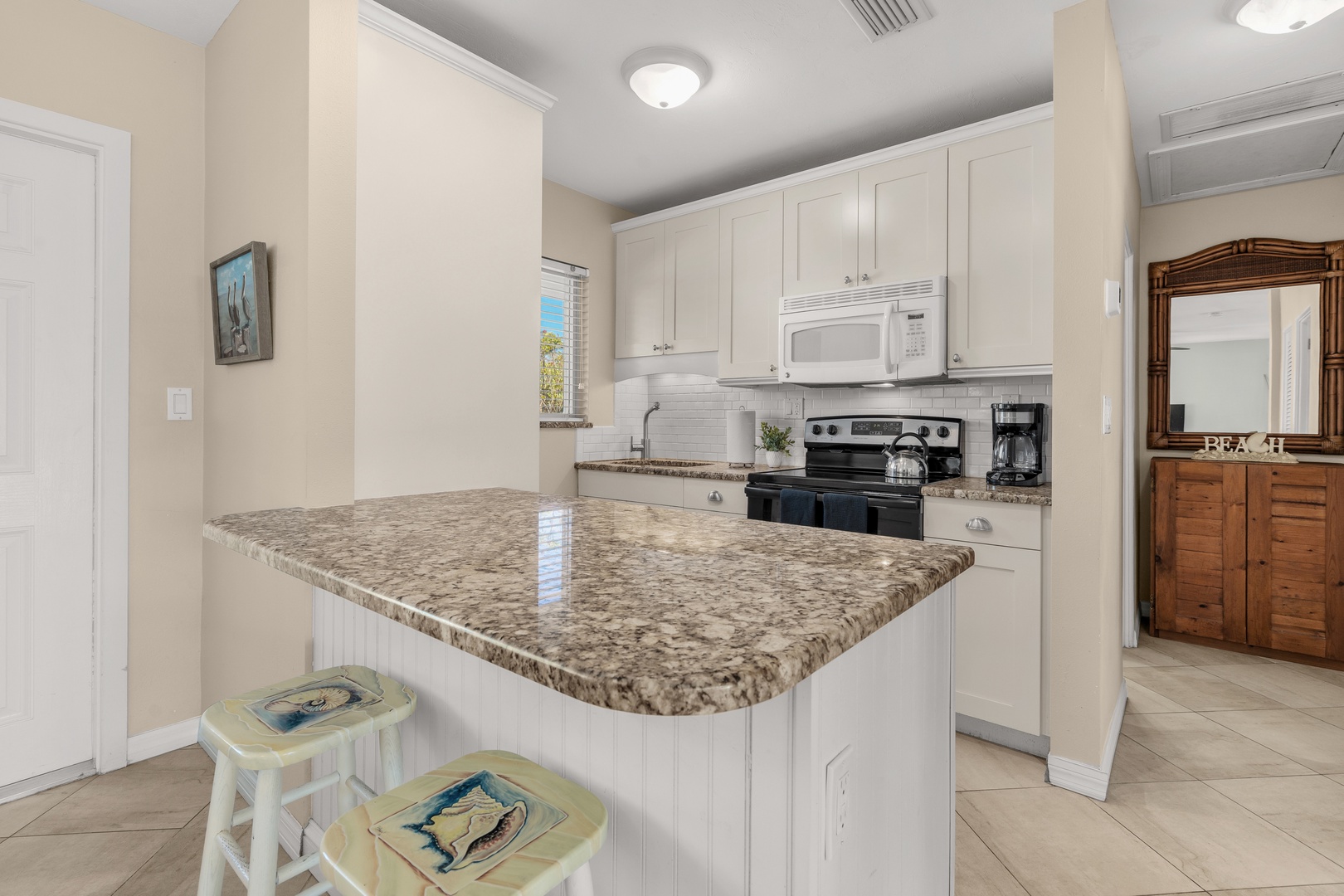 Your fully equipped kitchen features granite countertops, modern appliances, and a breakfast bar perfect for morning coffee.