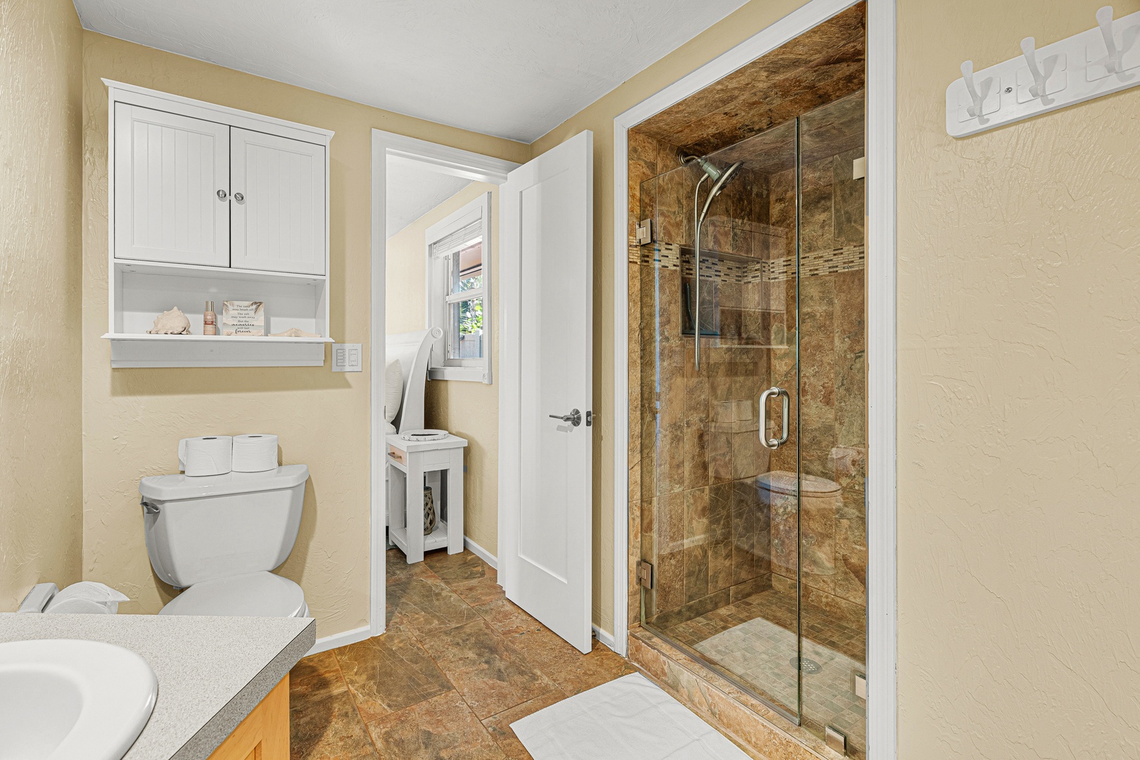 Step into your private sanctuary with a spacious walk-in shower and warm, inviting tile that wraps you in comfort after a day of exploring.