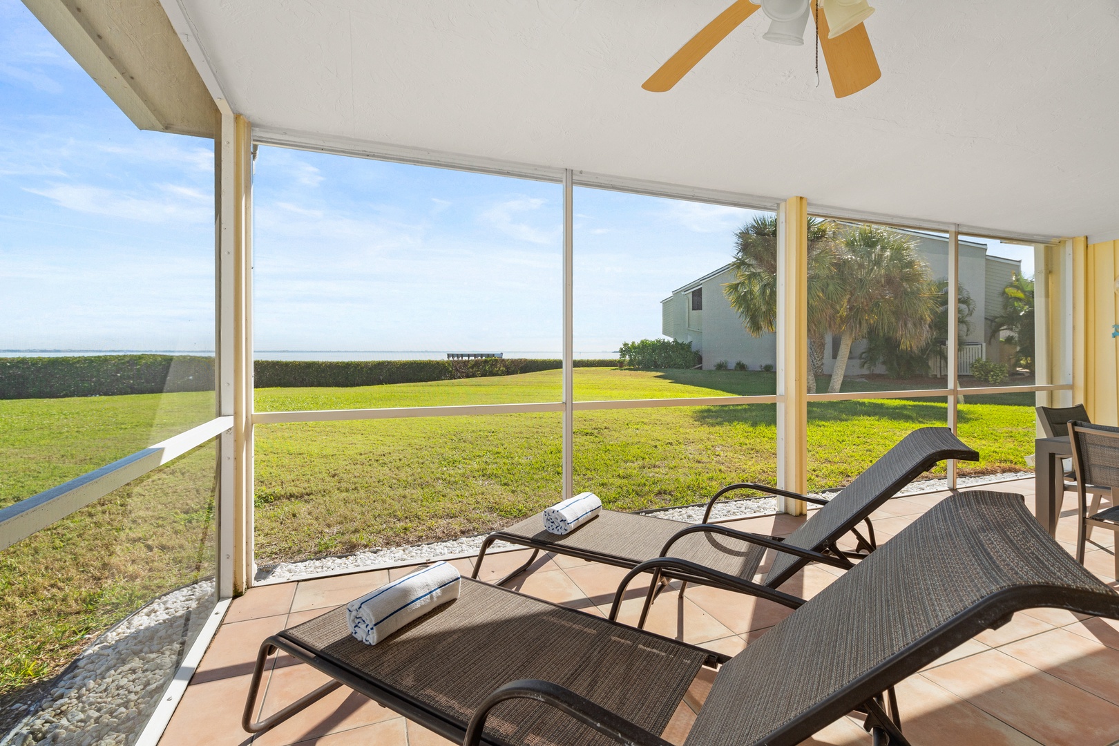 Relax on your private screened patio with panoramic garden views and comfortable loungers, where ocean breezes and peaceful surroundings create your perfect retreat.