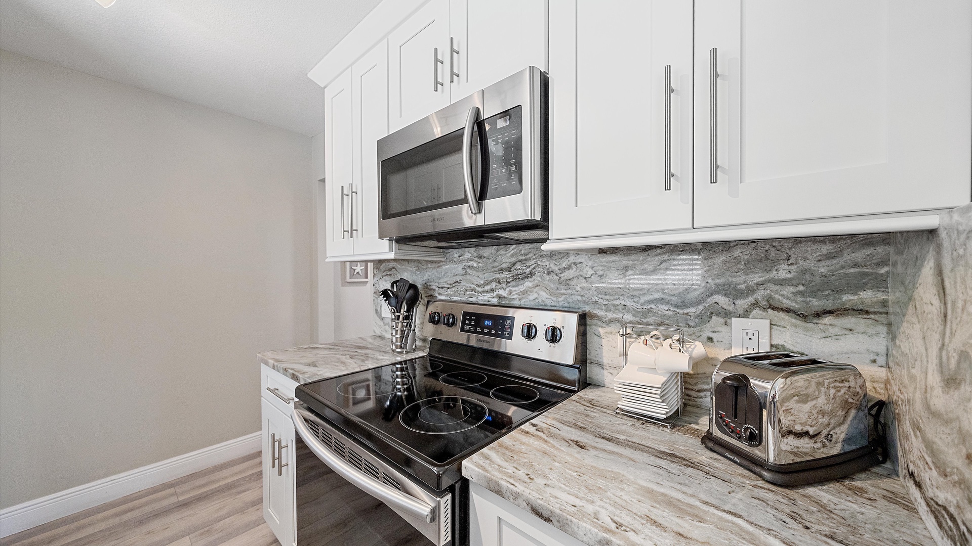 Step into your fully equipped kitchen with stylish white cabinetry, elegant marble countertops, and modern stainless steel appliances—everything you need for whipping up meals during your stay.