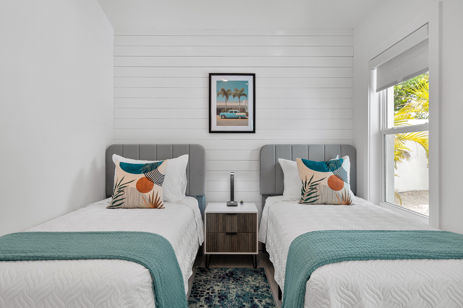 Relax in your bright, coastal-styled bedroom with two comfy twin beds, breezy tropical views from the window, and cheerful décor that invites restful sleep and easy mornings.