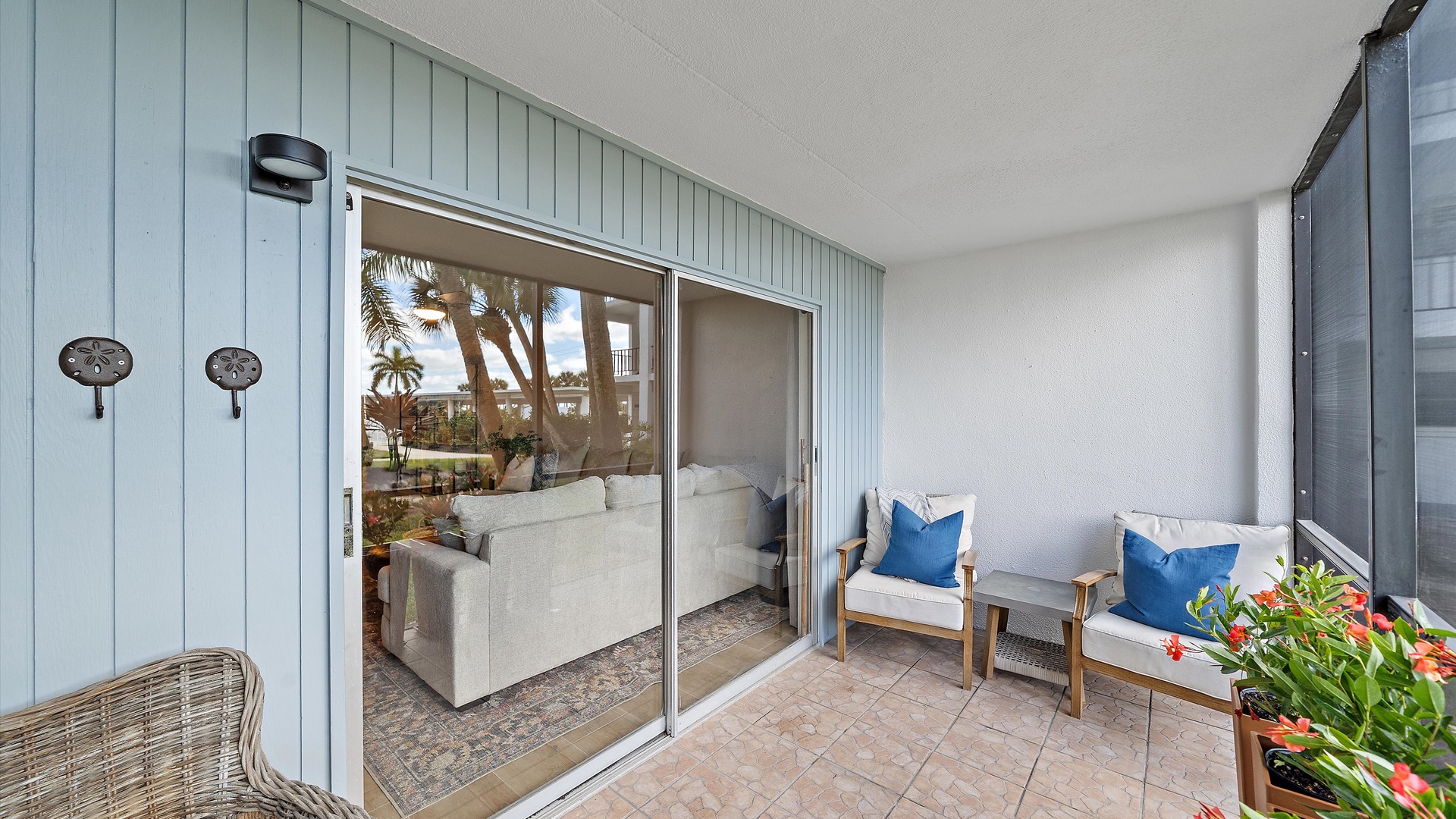 Step onto your private terrace where coastal charm meets comfort with stylish seating and cheerful flowers framing tropical views.