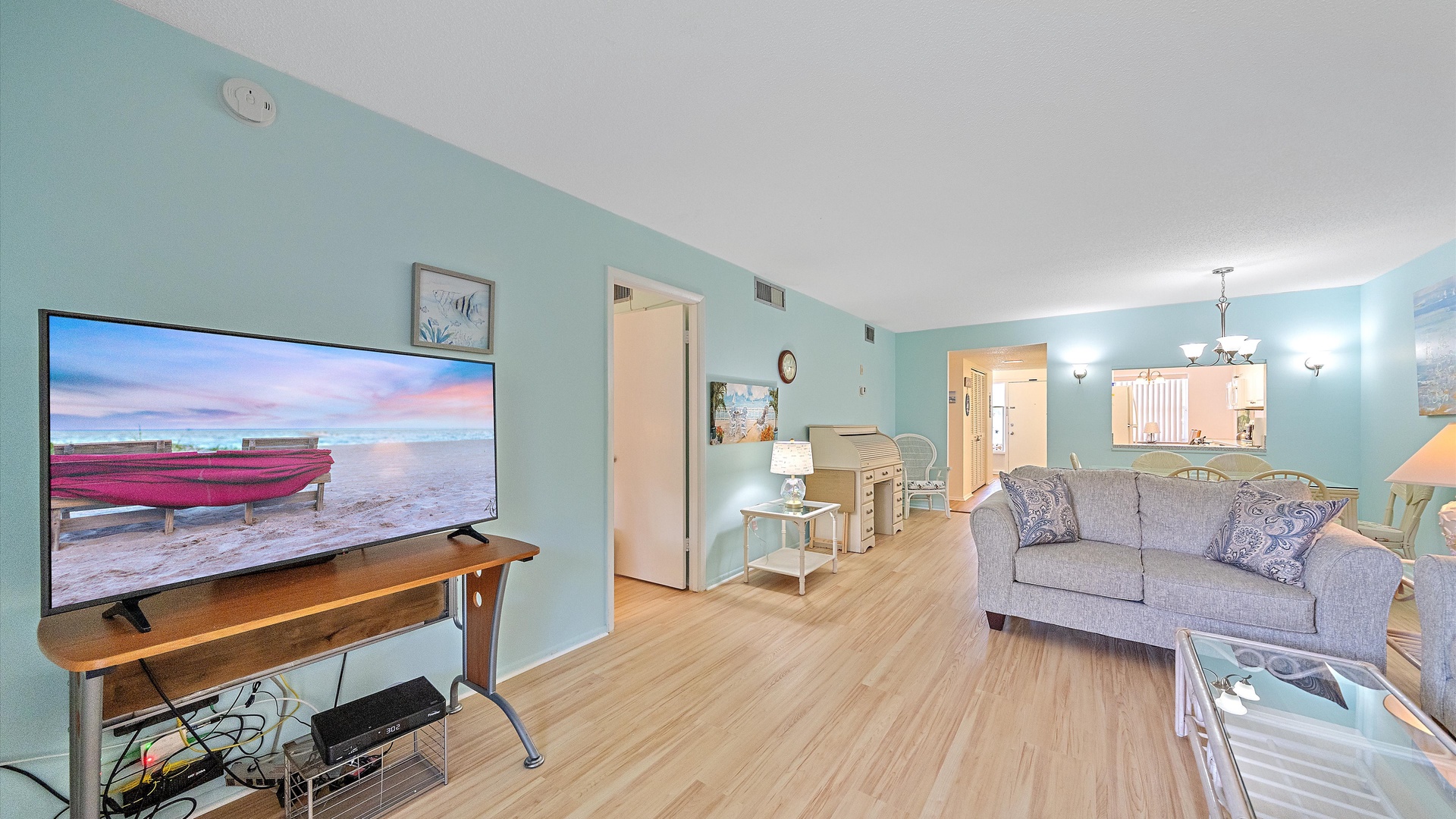 Unwind in your coastal-inspired living room, where calming aqua walls and cozy furnishings invite you to relax after beach-filled days.